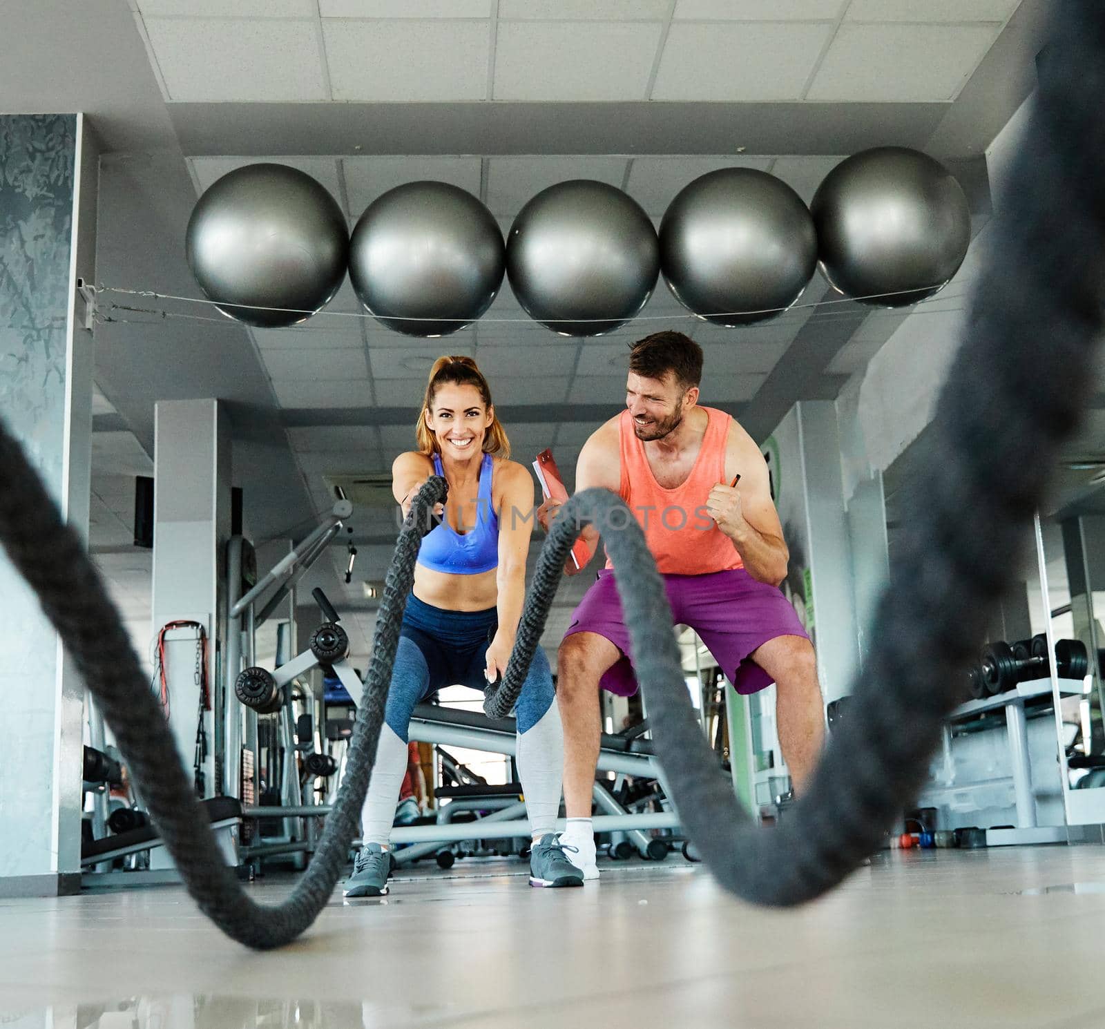 Portrait of a healthy fit woman at the gym exercising with a rope