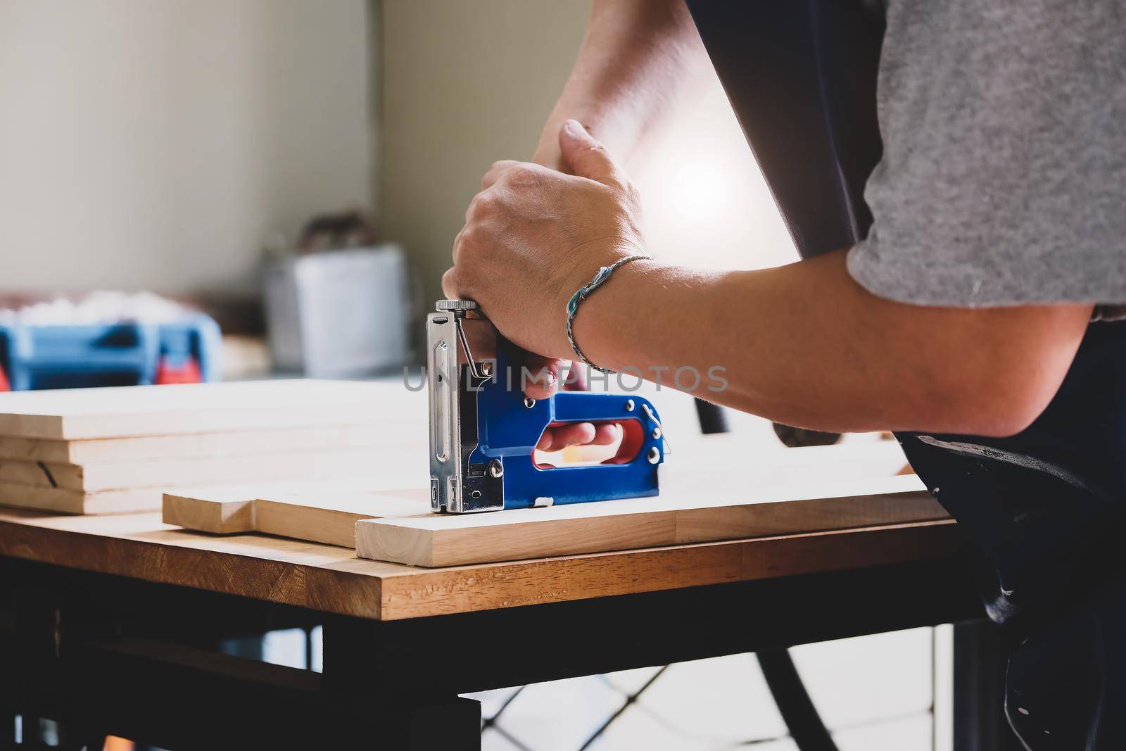 Entrepreneur Woodwork holding a Tacker to assemble the wood pieces as the customer ordered by Manastrong