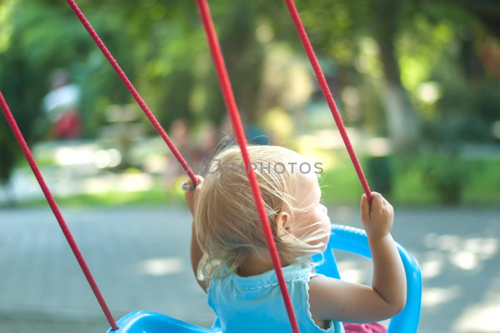 toddler girl on a swing in the park. High quality photo