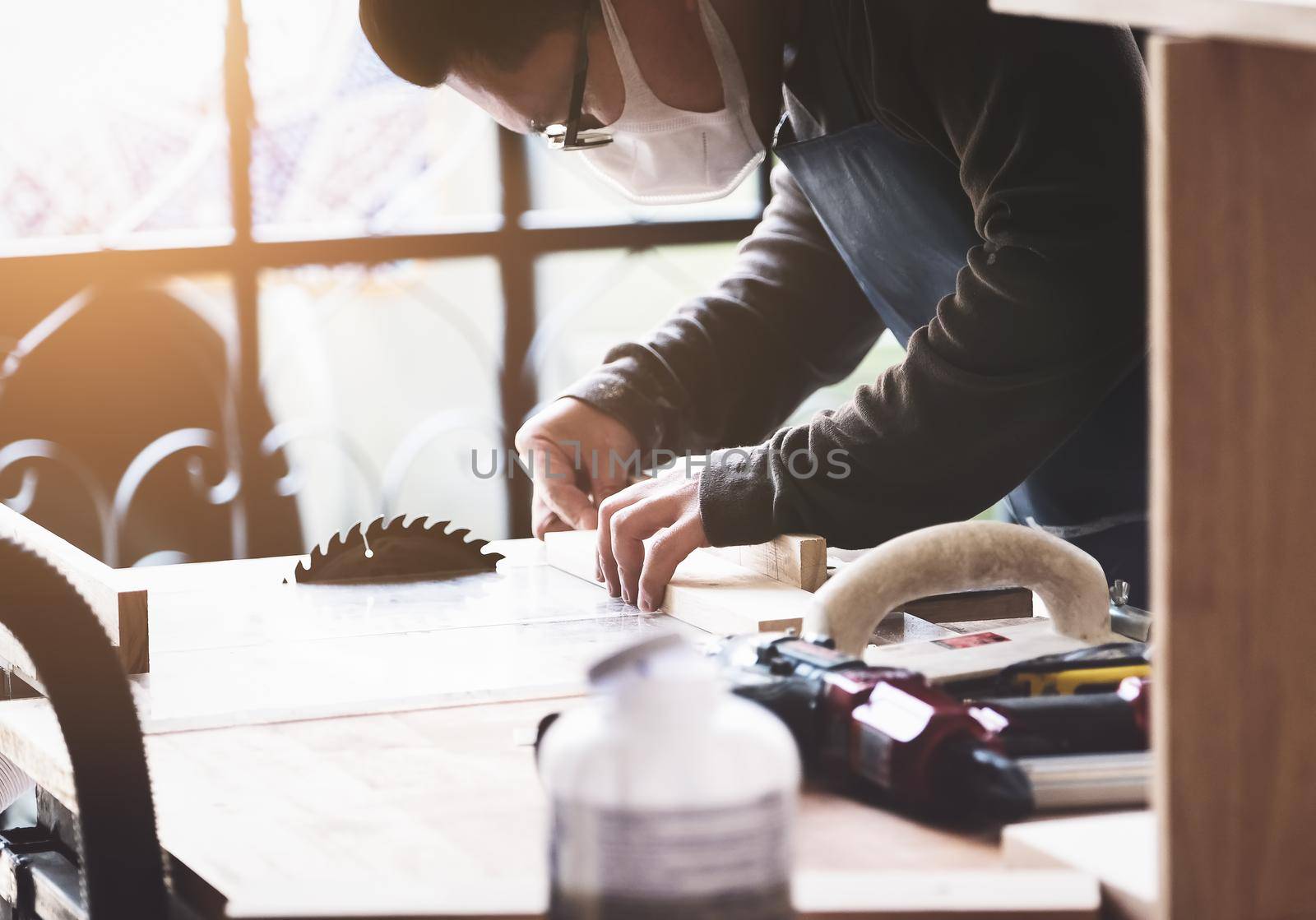 Woodworking practitioners use saw blades to cut wood pieces to assemble and build wooden tables for their clients