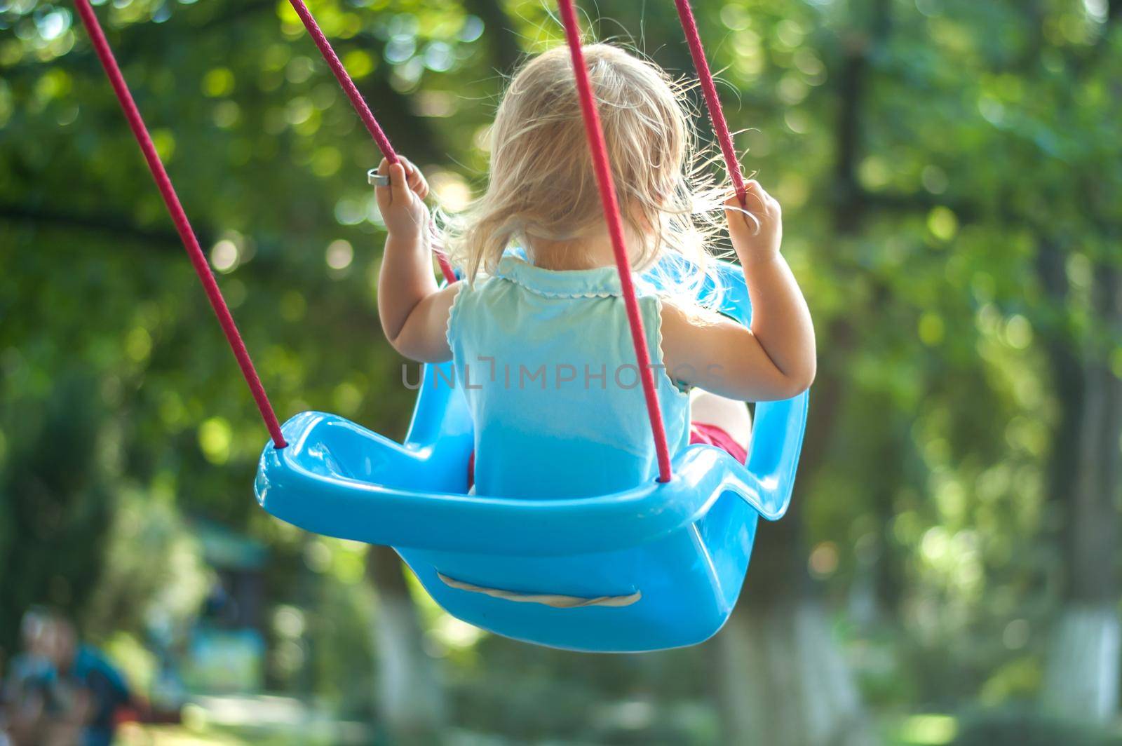 toddler girl on a swing in the park. High quality photo