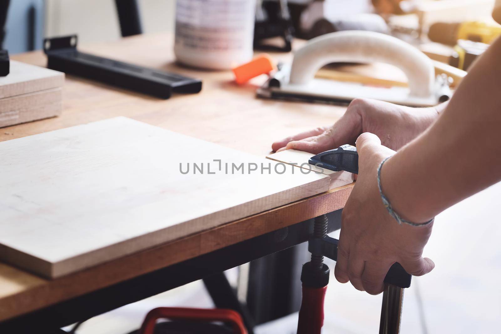 Woodworking operators are decorating pieces of wood to assemble and build wooden tables for customers.