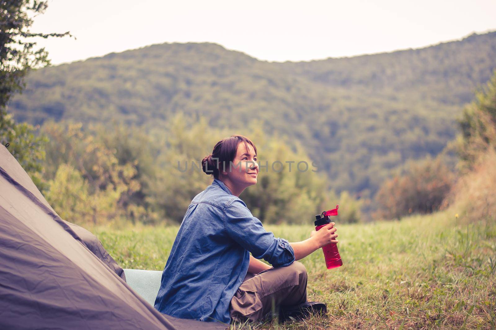 woman among the mountains near the tent enjoys nature. High quality photo