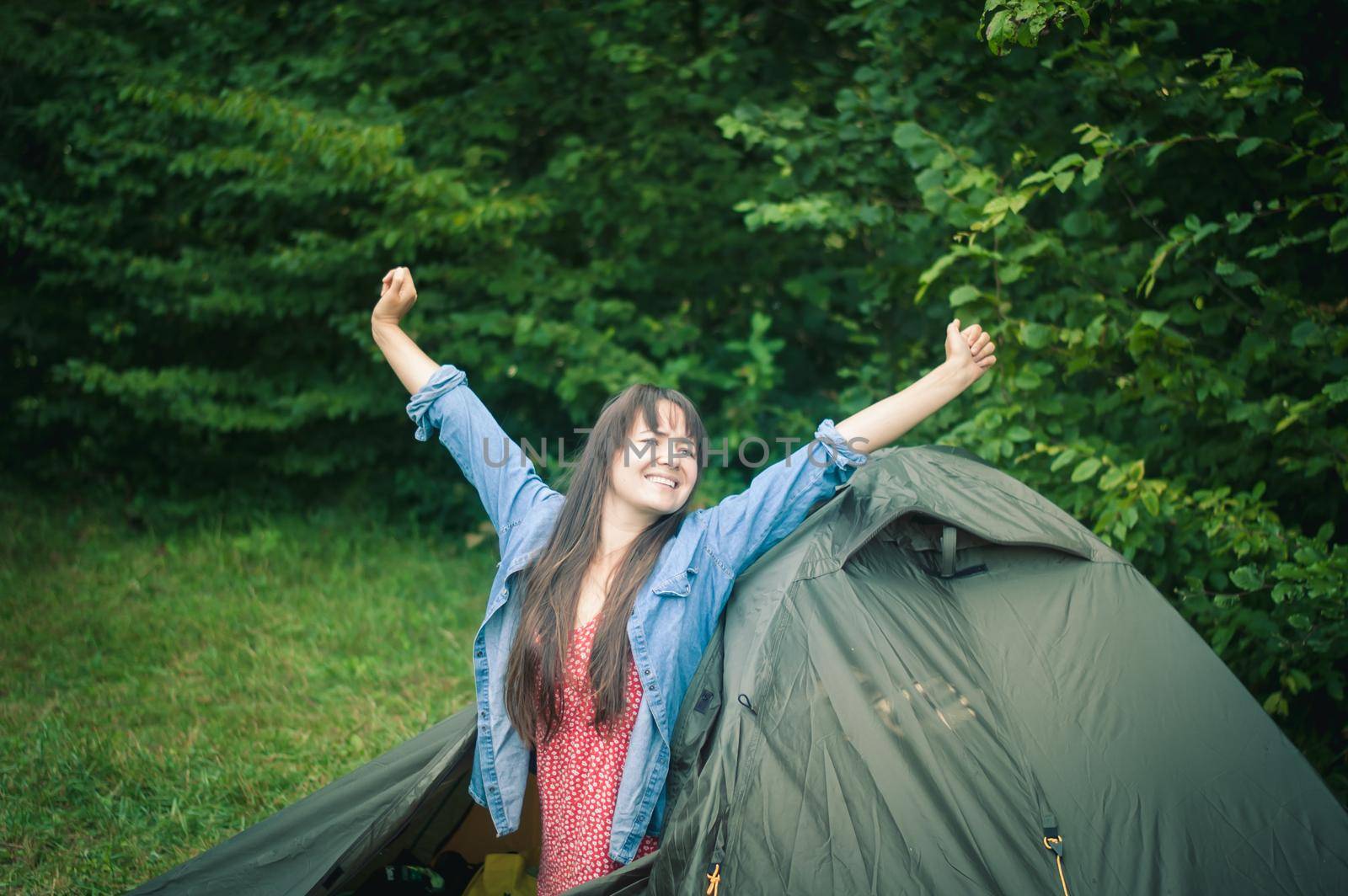 woman among the mountains near the tent enjoys nature. High quality photo