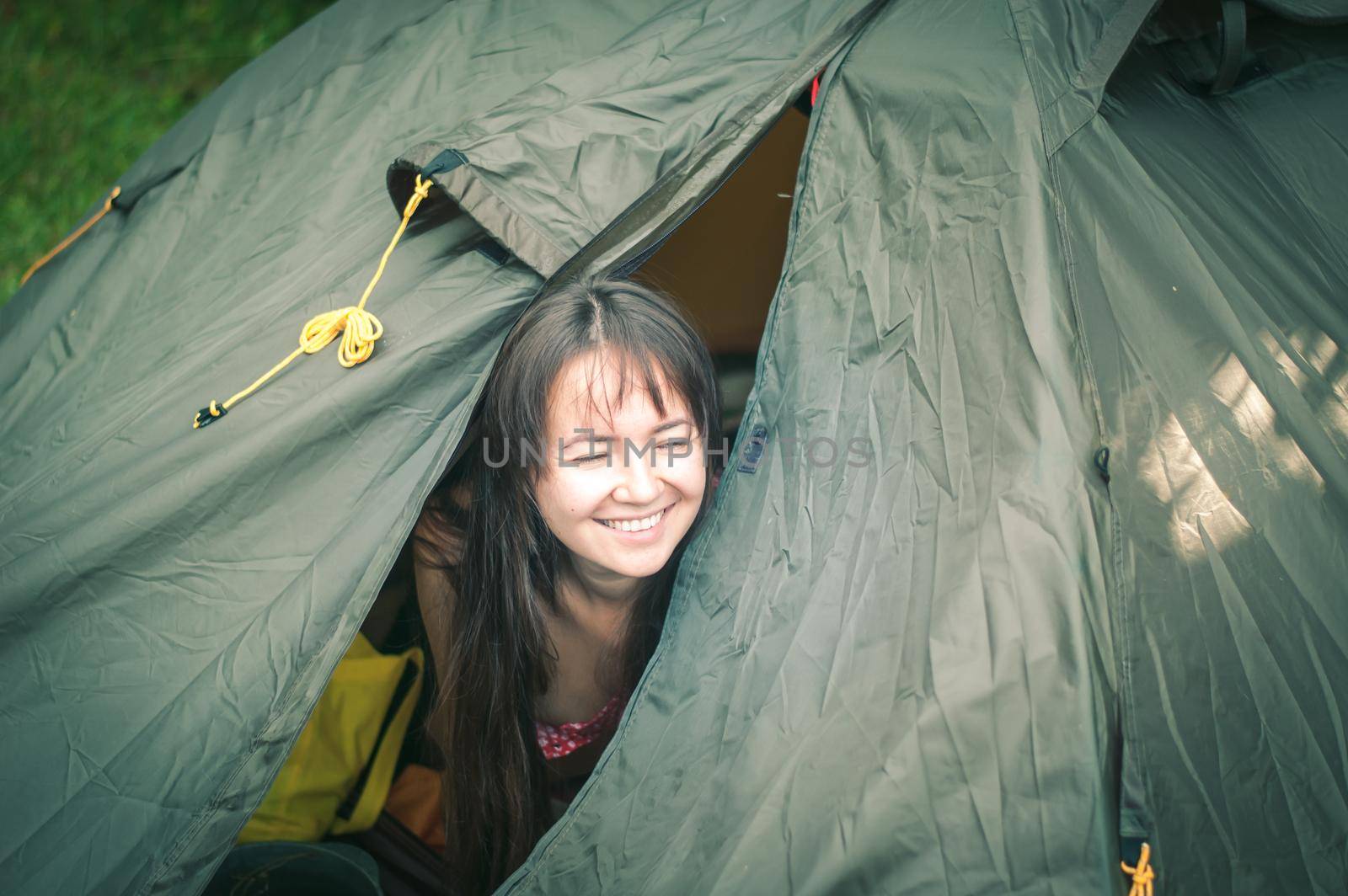 woman among the mountains near the tent enjoys nature. High quality photo