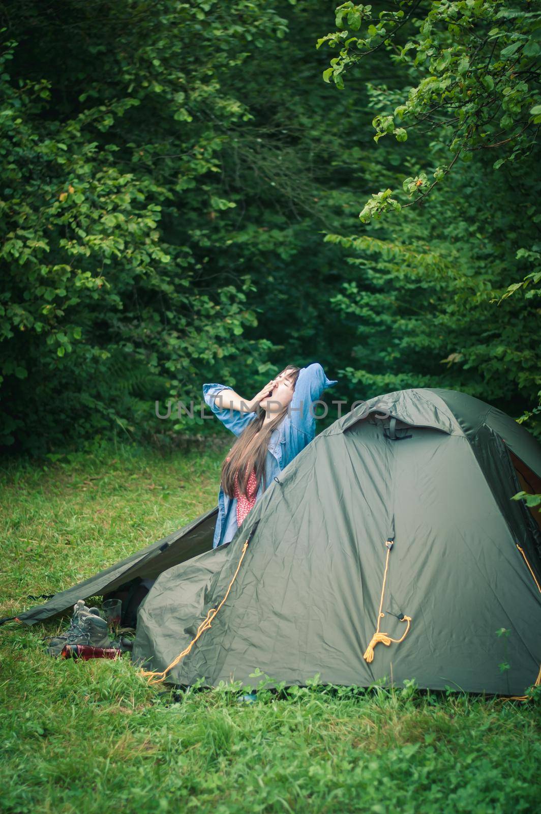 woman among the mountains near the tent enjoys nature. High quality photo