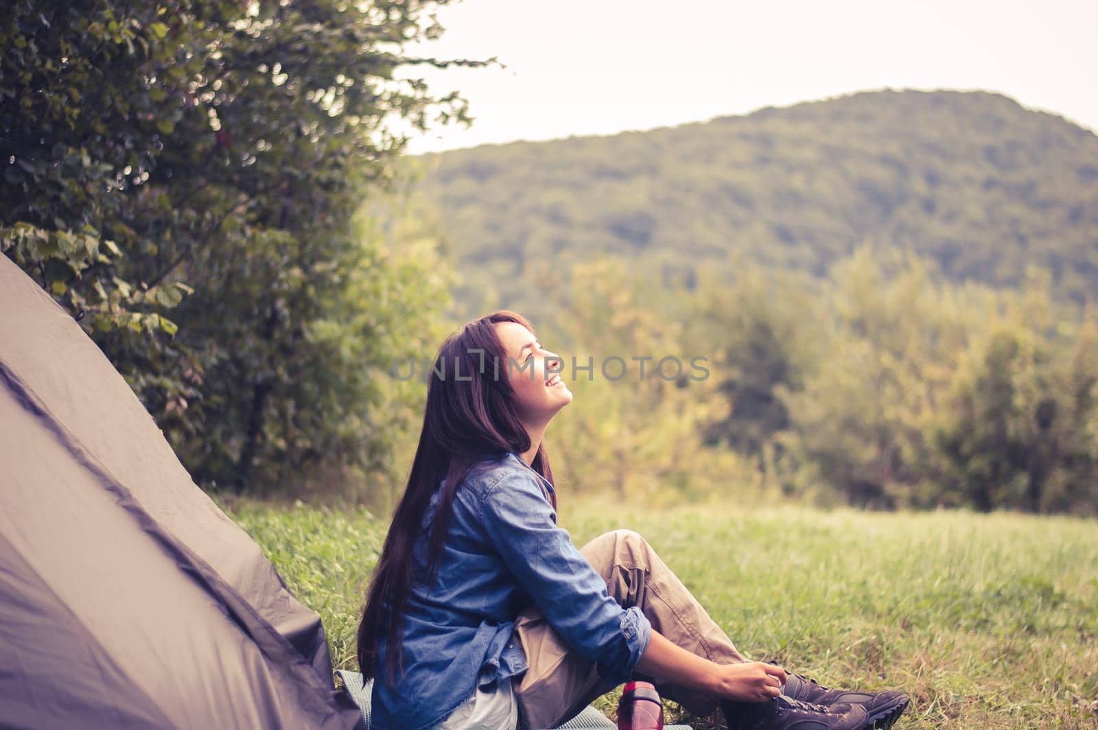 woman among the mountains near the tent enjoys nature. High quality photo