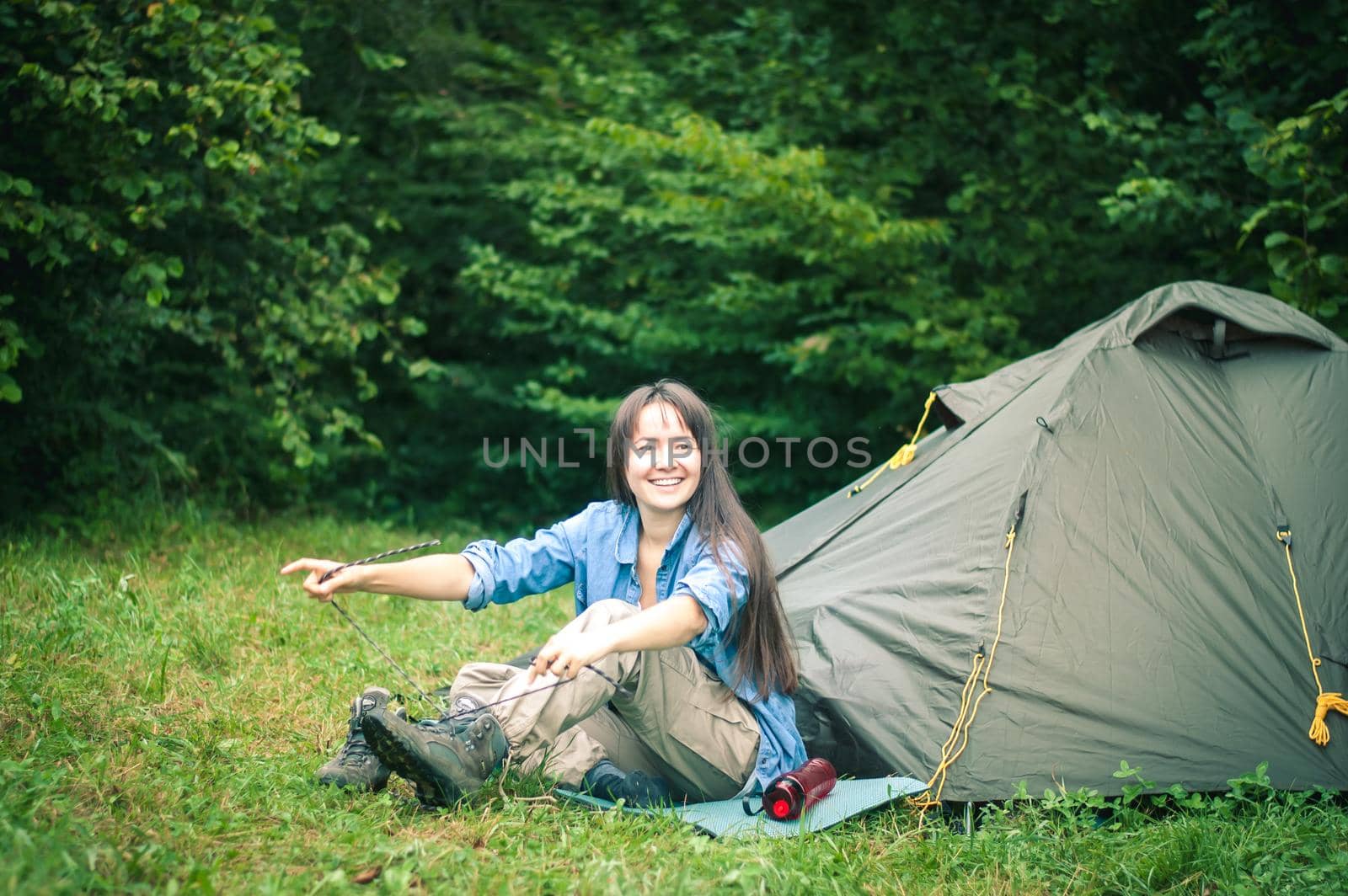 woman among the mountains near the tent enjoys nature. High quality photo