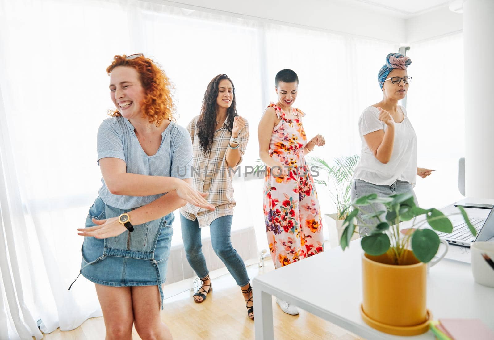 Happy young people friends dancing in the office