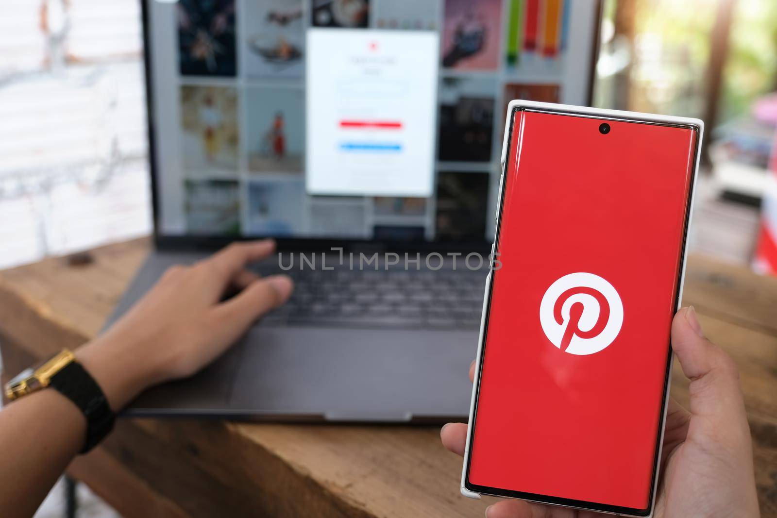 Chiangmai, THAILAND - June 06, 2021:woman Hand holding smartphone mobile with Pinterest app on the screen. Pinterest is an online pinboard that allows people to pin their interesting things by Manastrong