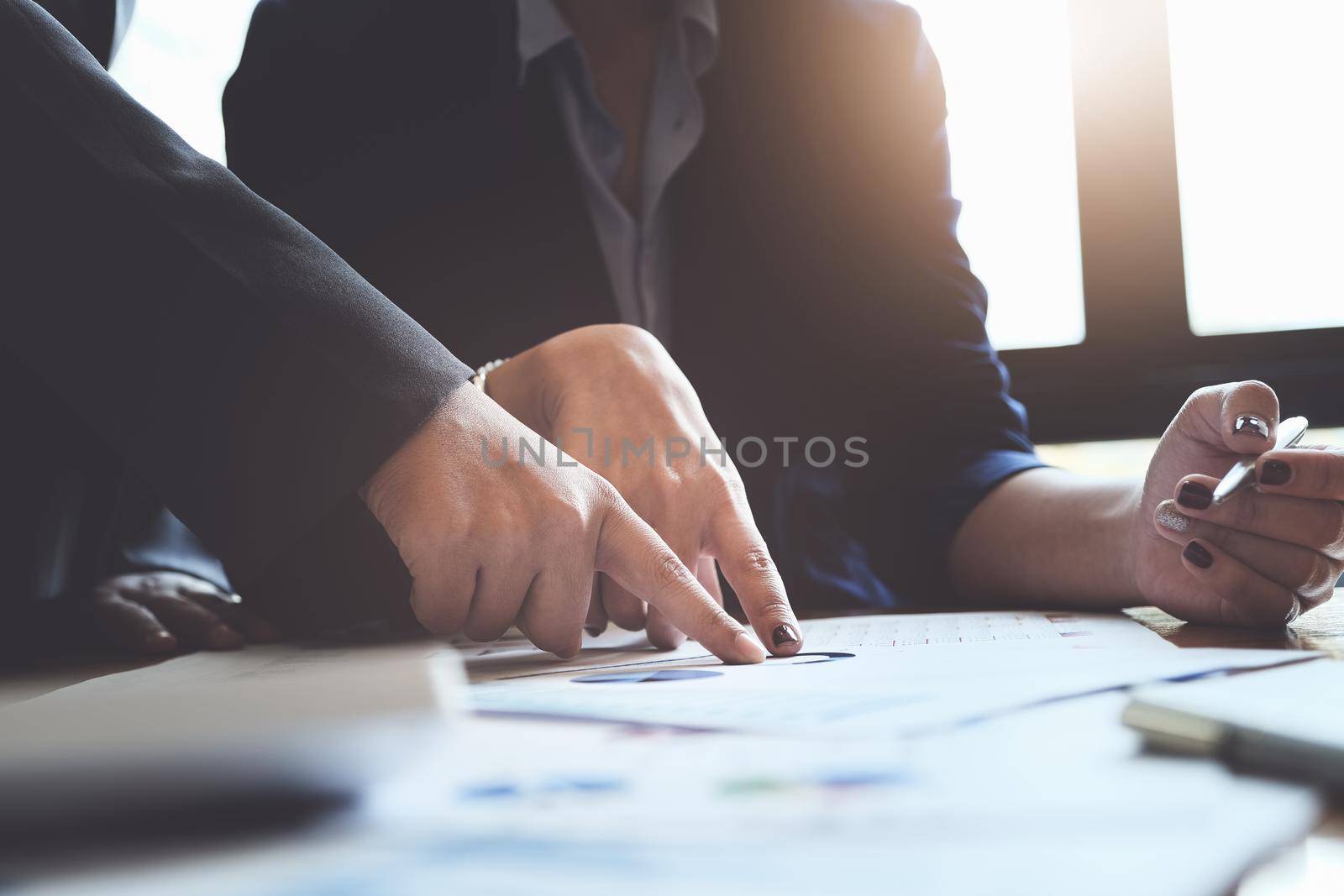 An auditor pointing to documents to examine budgets and financial fraud