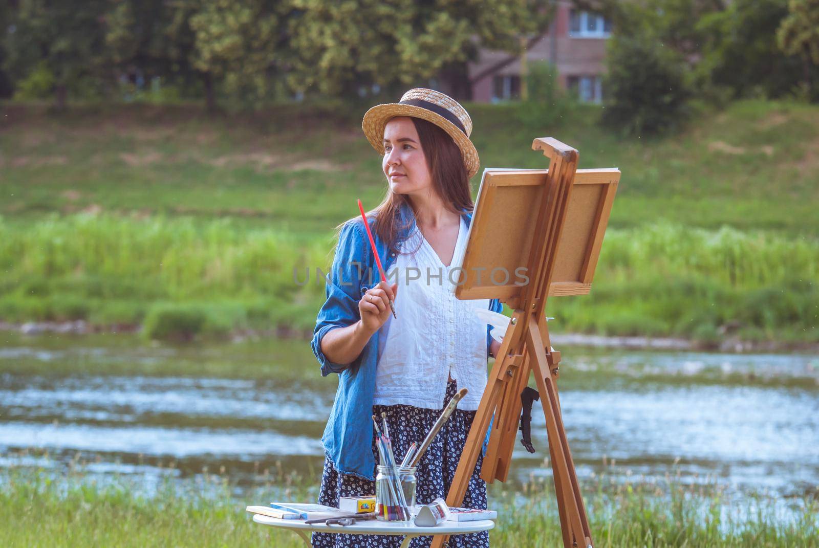 beautiful girl artist outdoor with wooden aesel and watercolor