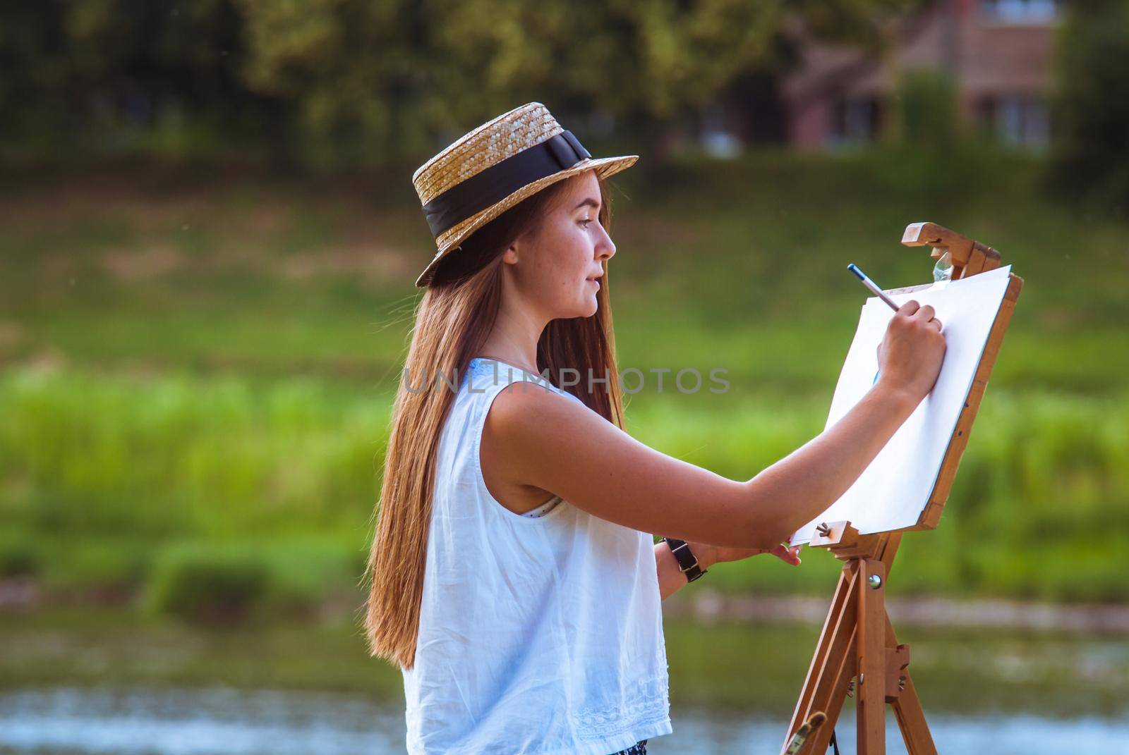 beautiful girl artist outdoor with wooden aesel and watercolor