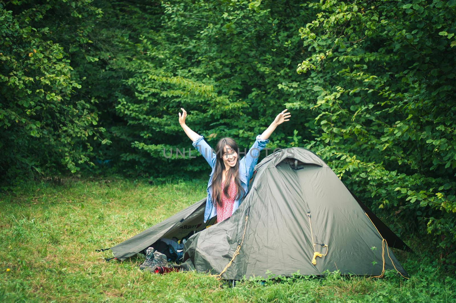 woman among the mountains near the tent enjoys nature. High quality photo