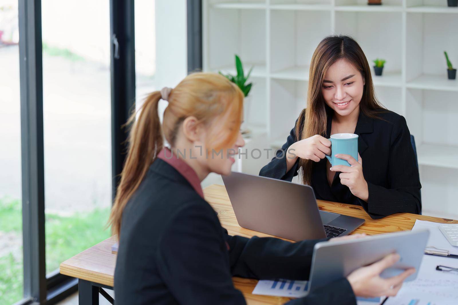 Portrait of a young Asian businesswoman consulting, planning marketing to improve product quality for customers by Manastrong