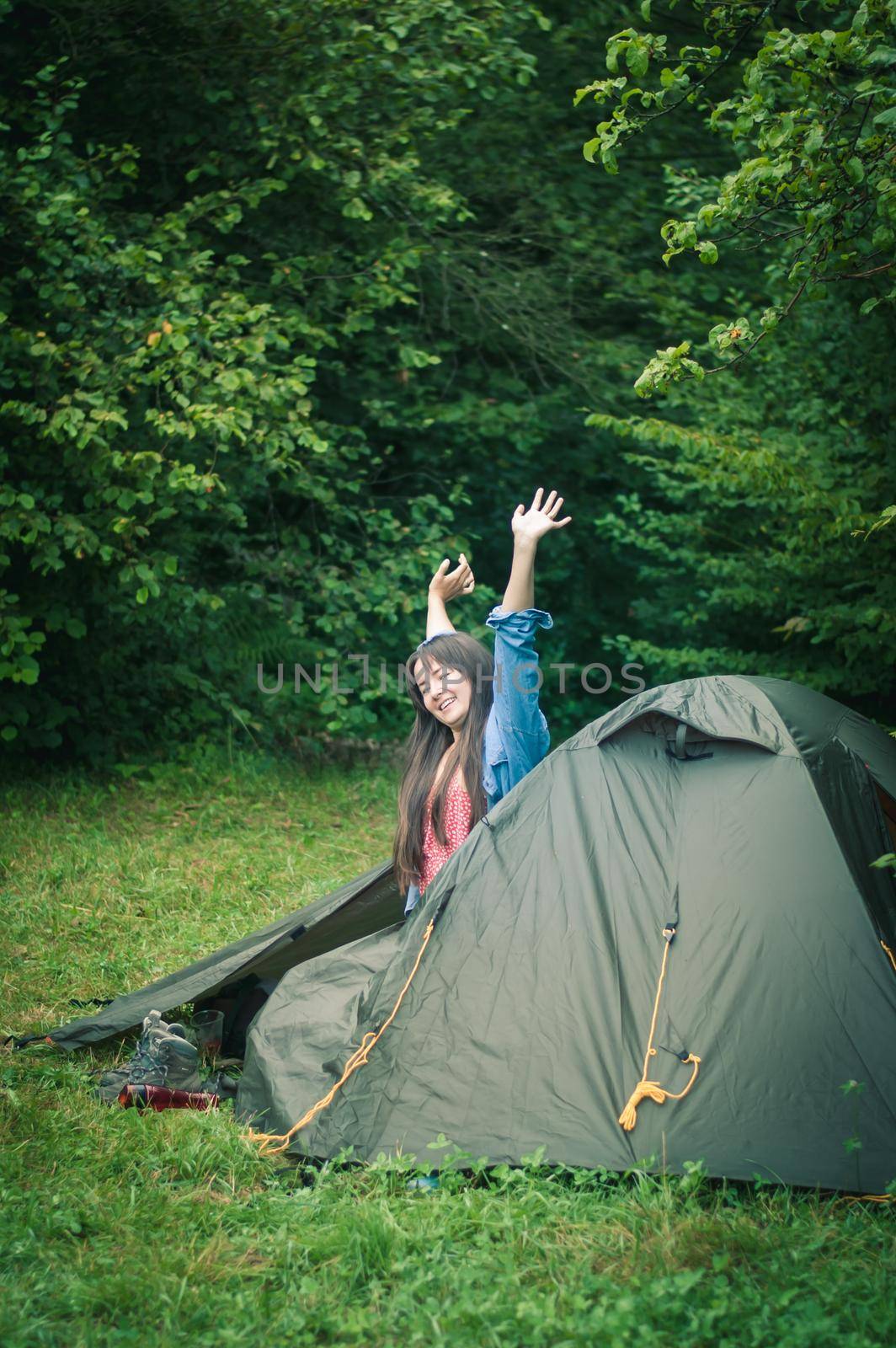 woman among the mountains near the tent enjoys nature. High quality photo