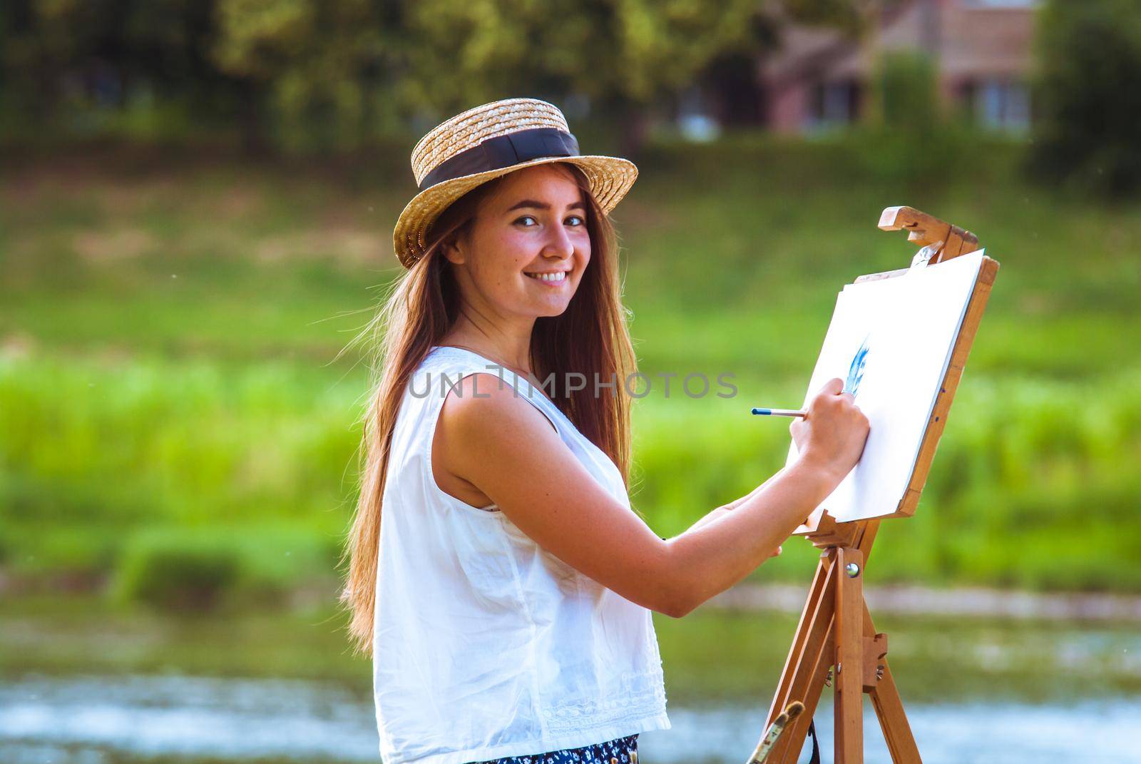 beautiful girl artist outdoor with wooden aesel and watercolor