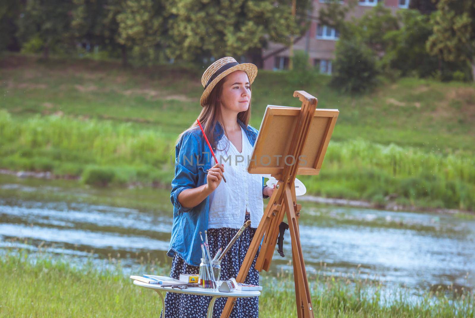 beautiful girl artist outdoor with wooden aesel and watercolor