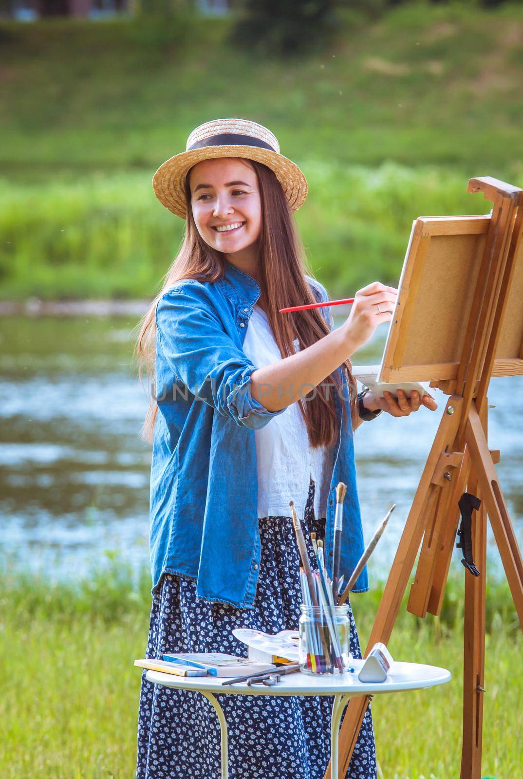 beautiful girl artist outdoor with wooden aesel and watercolor