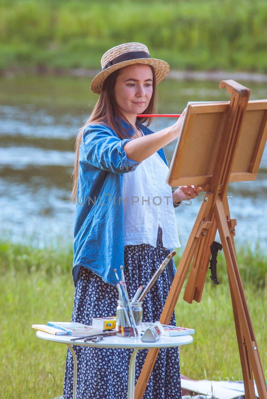 beautiful girl artist outdoor with wooden aesel and watercolor