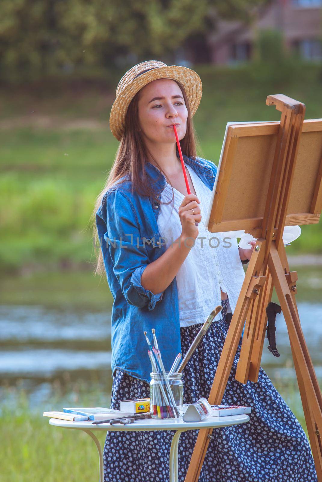 beautiful girl artist outdoor with wooden aesel and watercolor