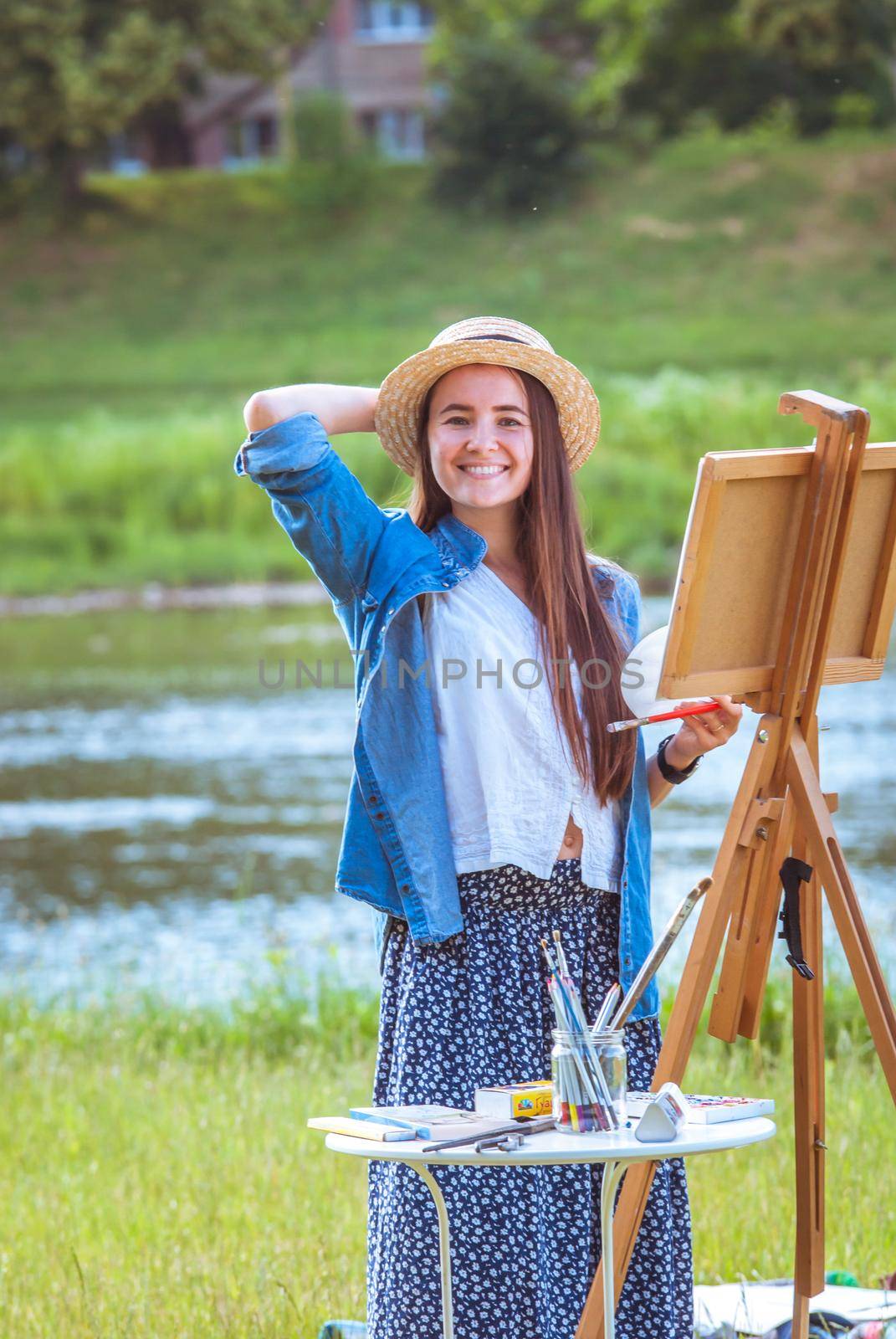 beautiful girl artist outdoor with wooden aesel and watercolor