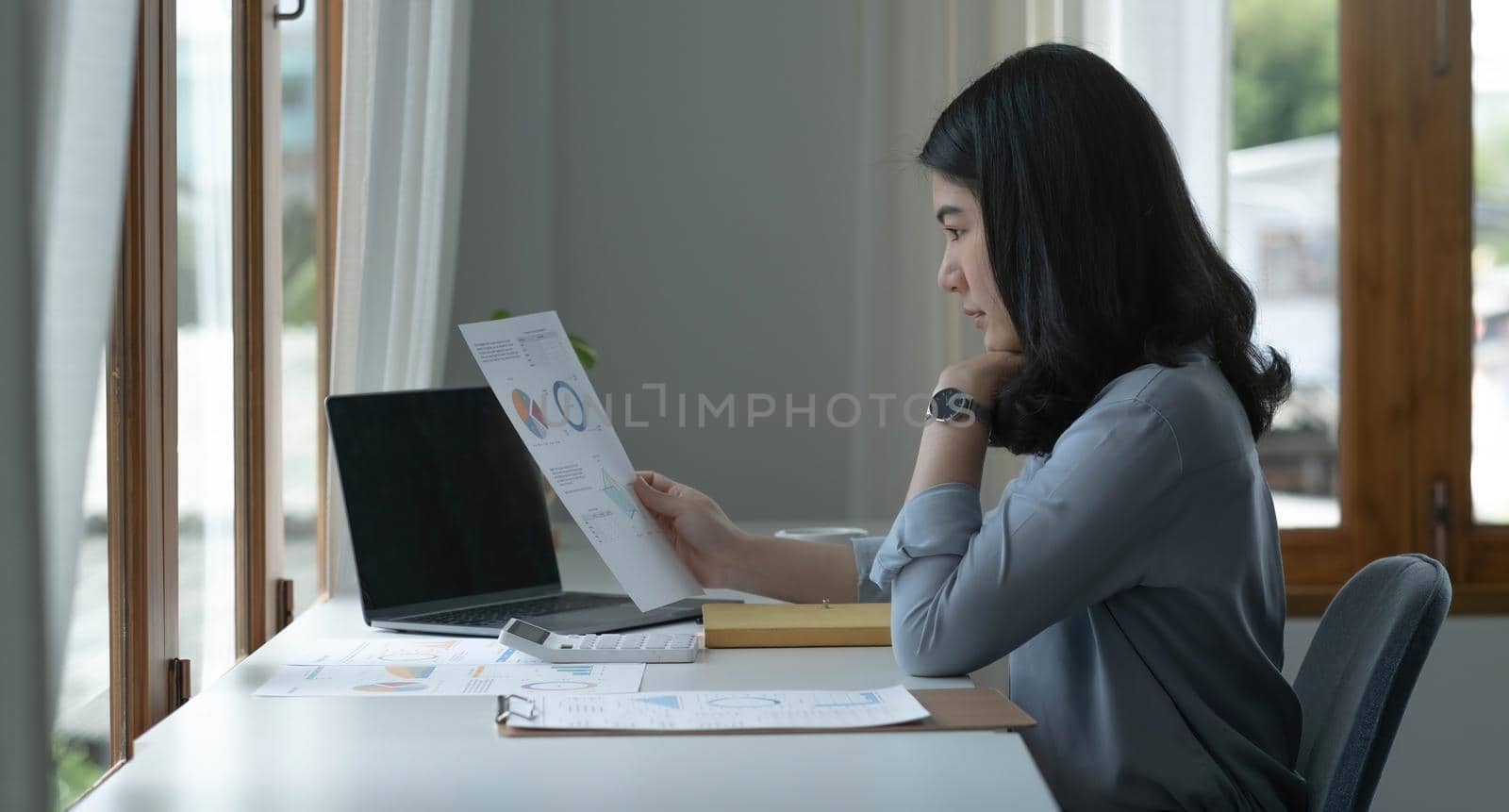 Asian businesswoman working in the office with working documents. by wichayada