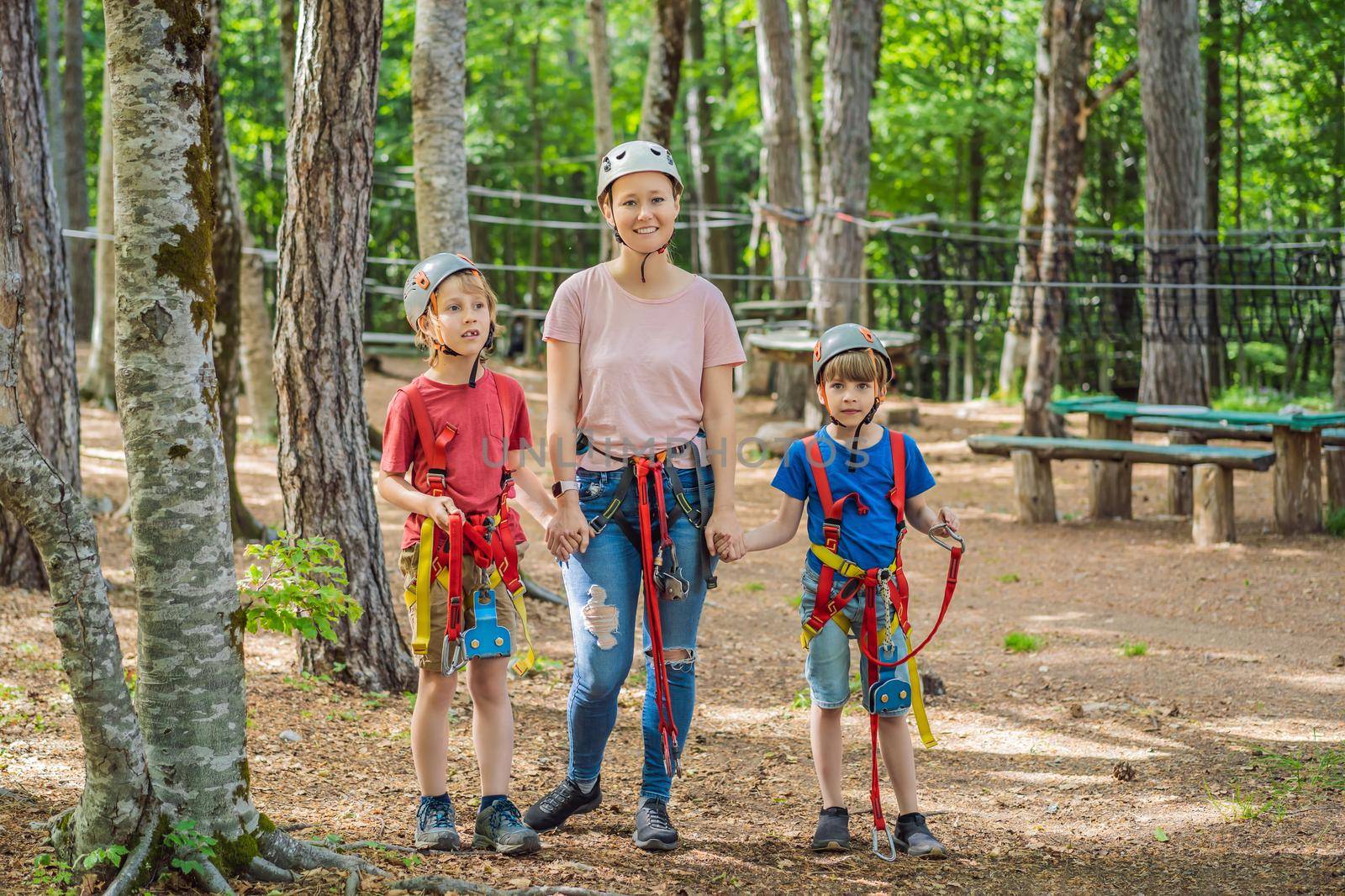 Friends on the ropes course. Young people in safety equipment are obstacles on the road rope by galitskaya