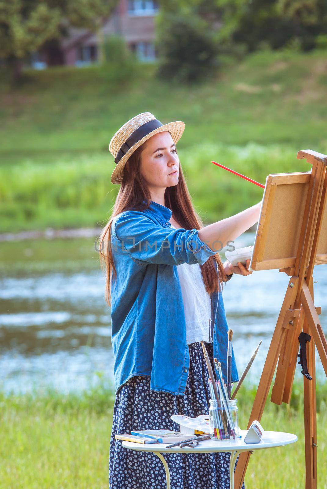 beautiful girl artist outdoor with wooden aesel and watercolor