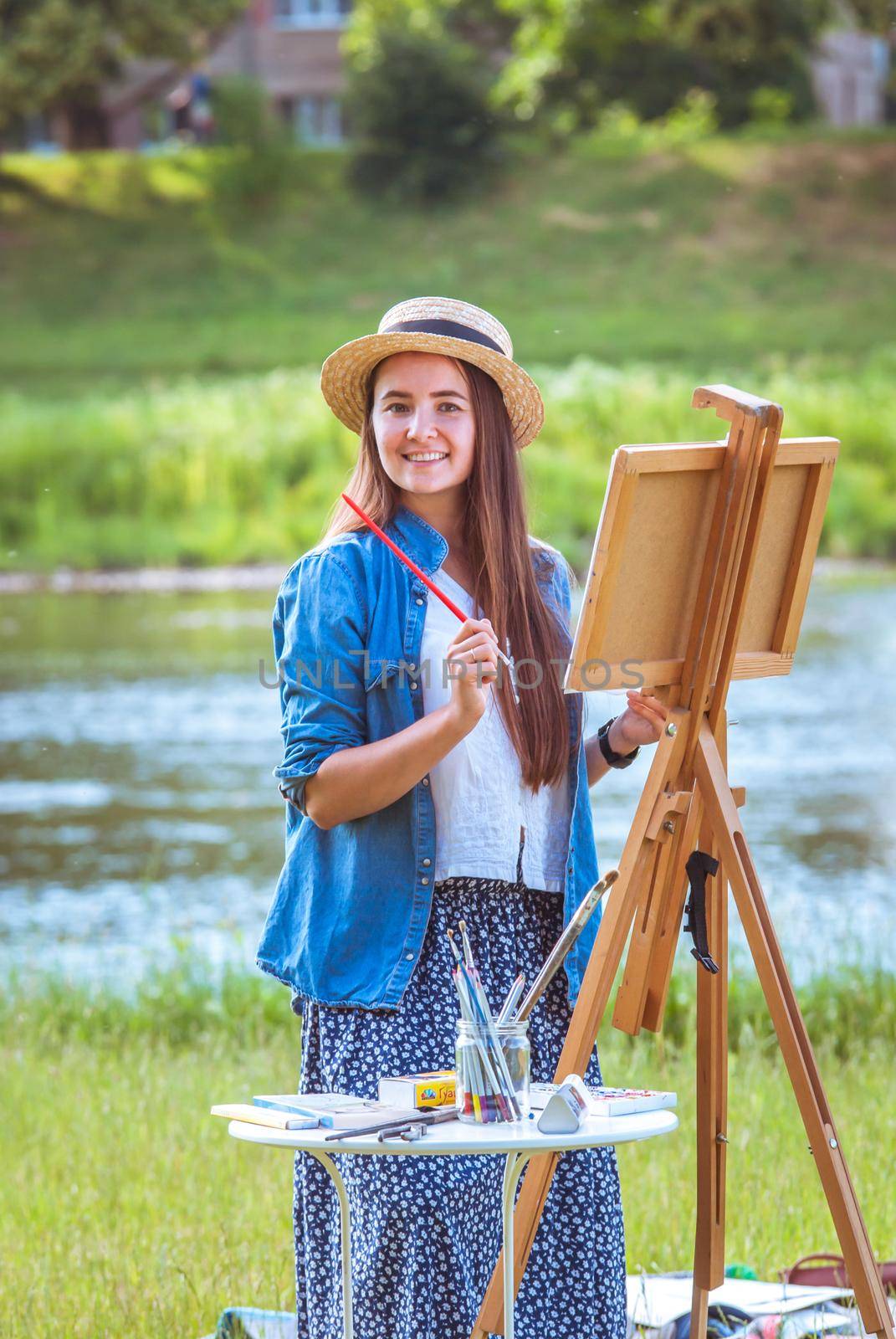 beautiful girl artist outdoor with wooden aesel and watercolor