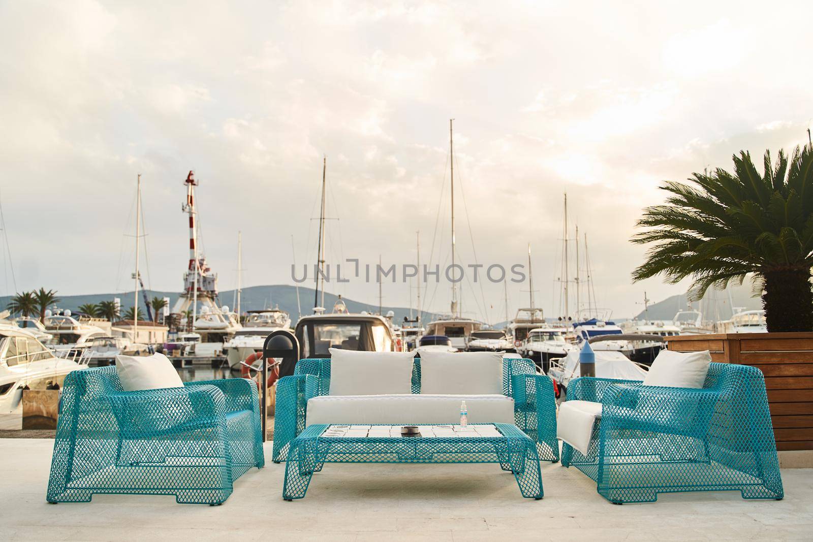 Wicker blue chairs, sofa and table. Summer outdoor furniture on the seashore by driver-s