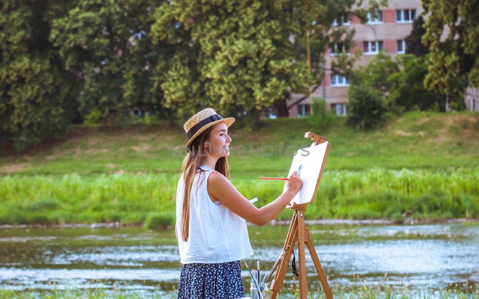 beautiful girl artist outdoor with wooden aesel and watercolor