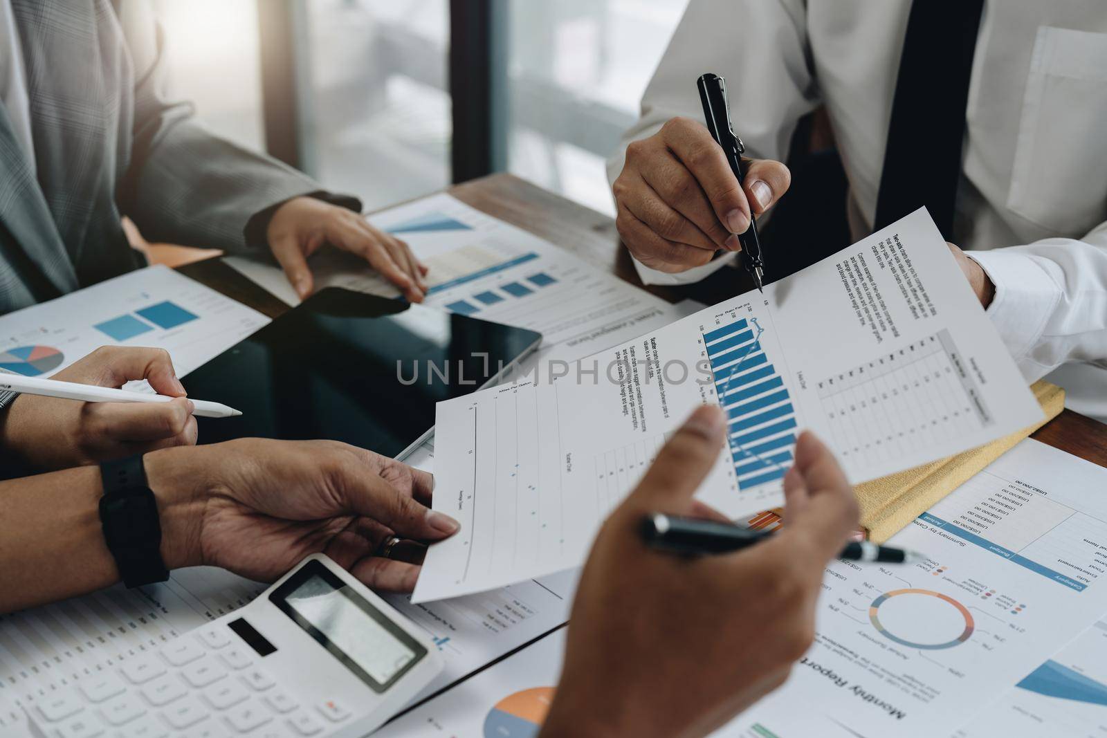 business consulting or finance budget plan, business advisor holding pen pointing to explain method profit with business owner use pen write to notebook and use laptop computer by nateemee