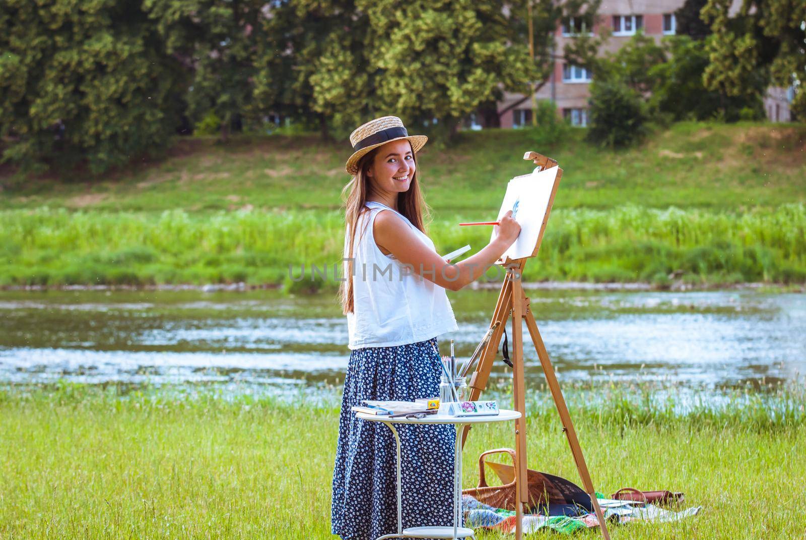 beautiful girl artist outdoor with wooden aesel and watercolor