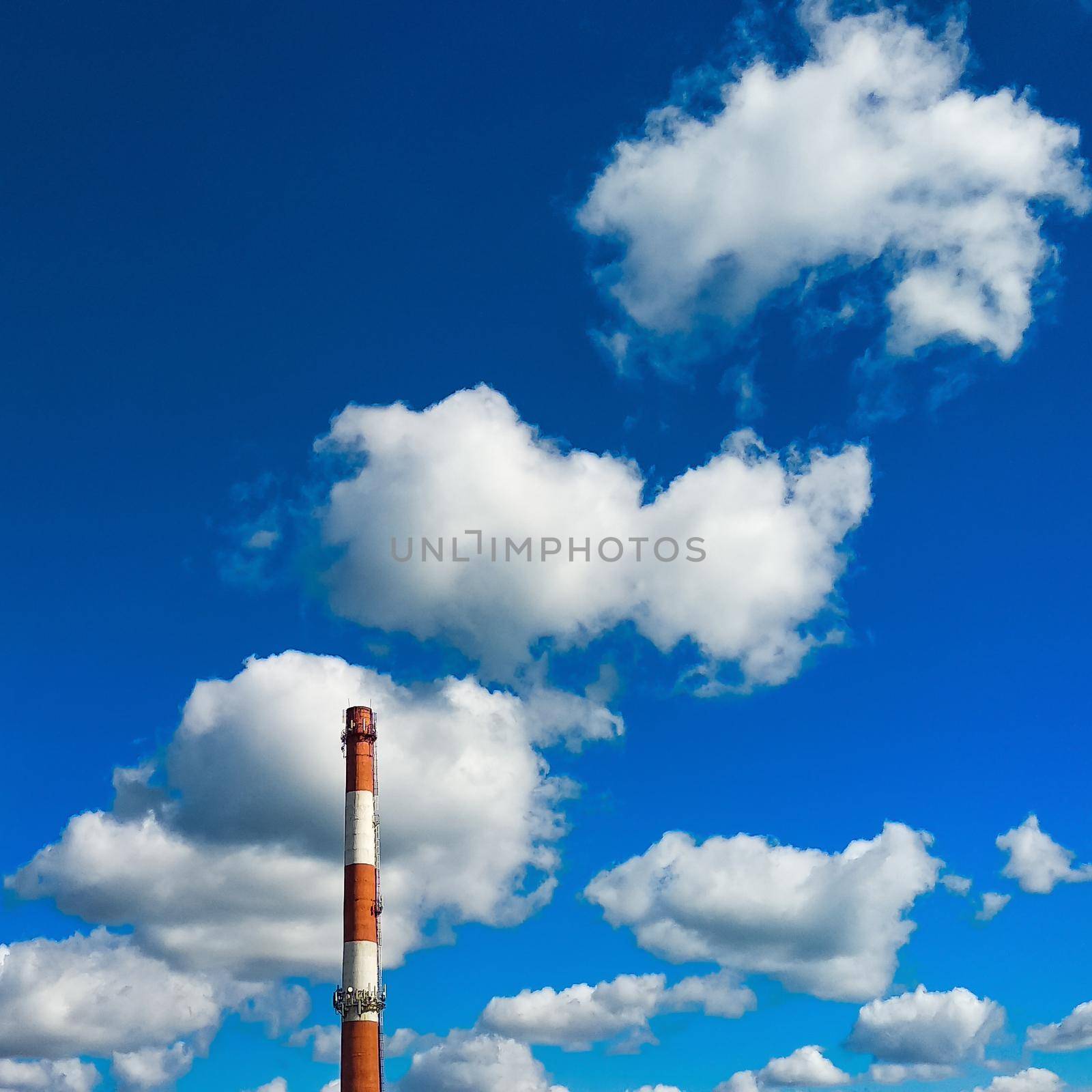 Boiler room chimney against a background of bright blue sky and white clouds