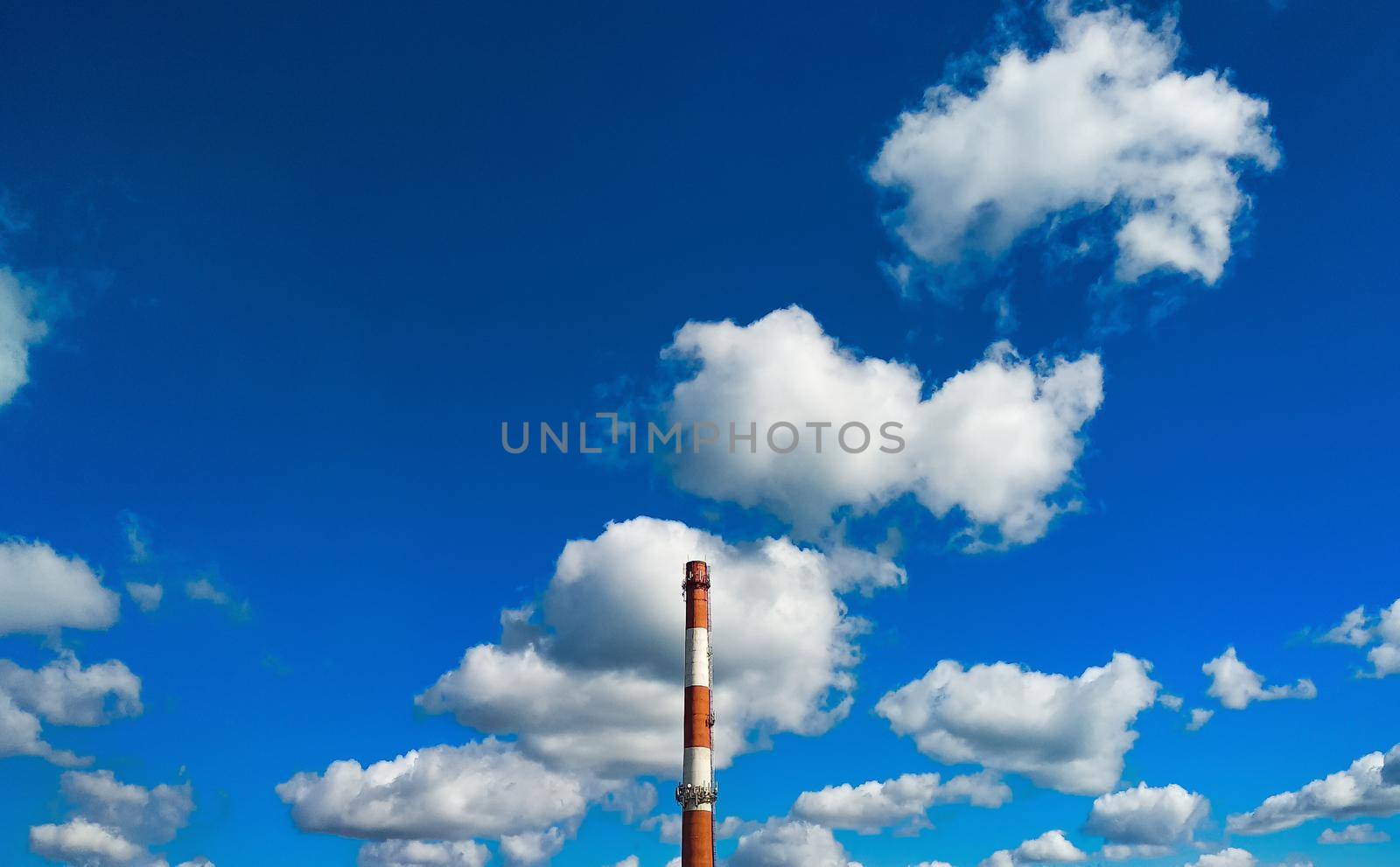 Boiler room chimney against a background of bright blue sky and white clouds