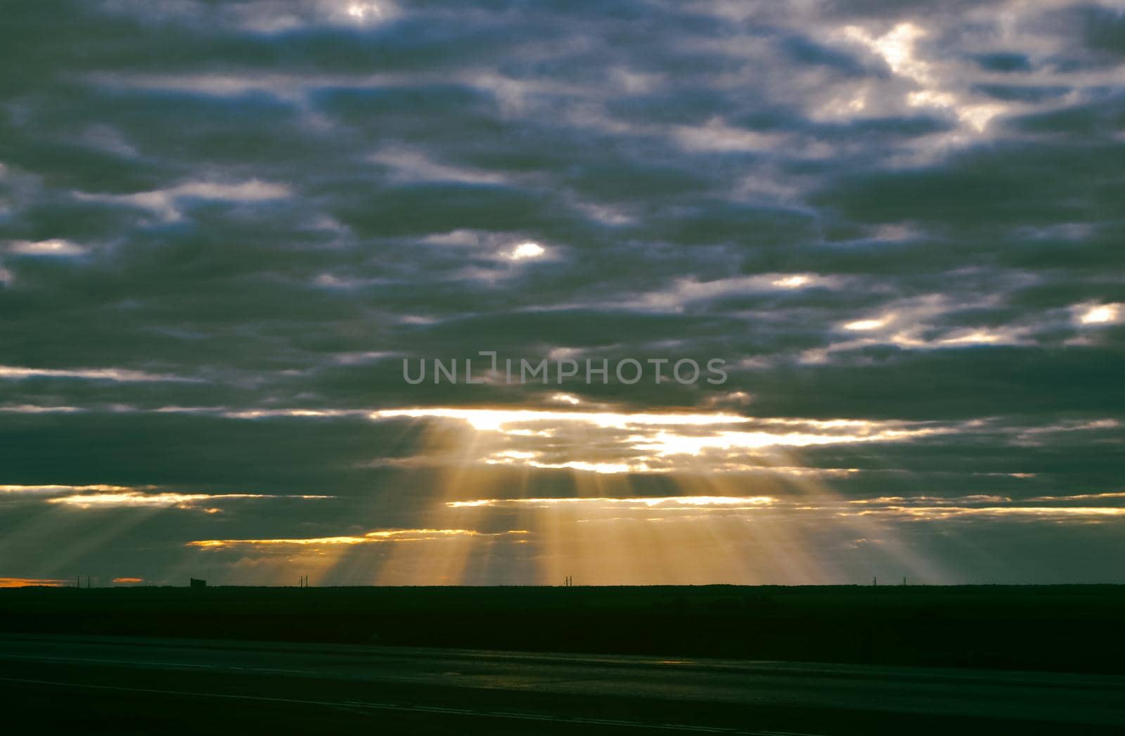 A landscape in which the rays of the sun are photographed, which make their way through the evening sky in the steppe by ProjectStockman