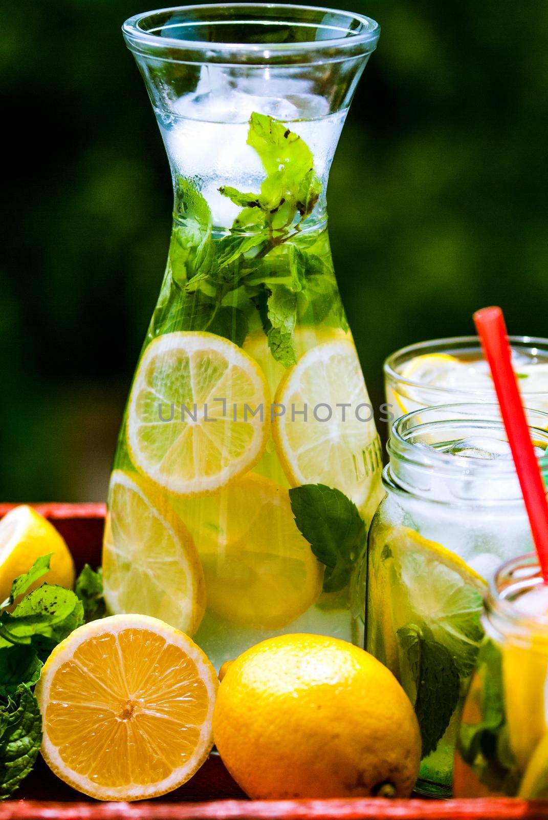 Delicious homemade lemonade in graphene and jars with mint and lemons