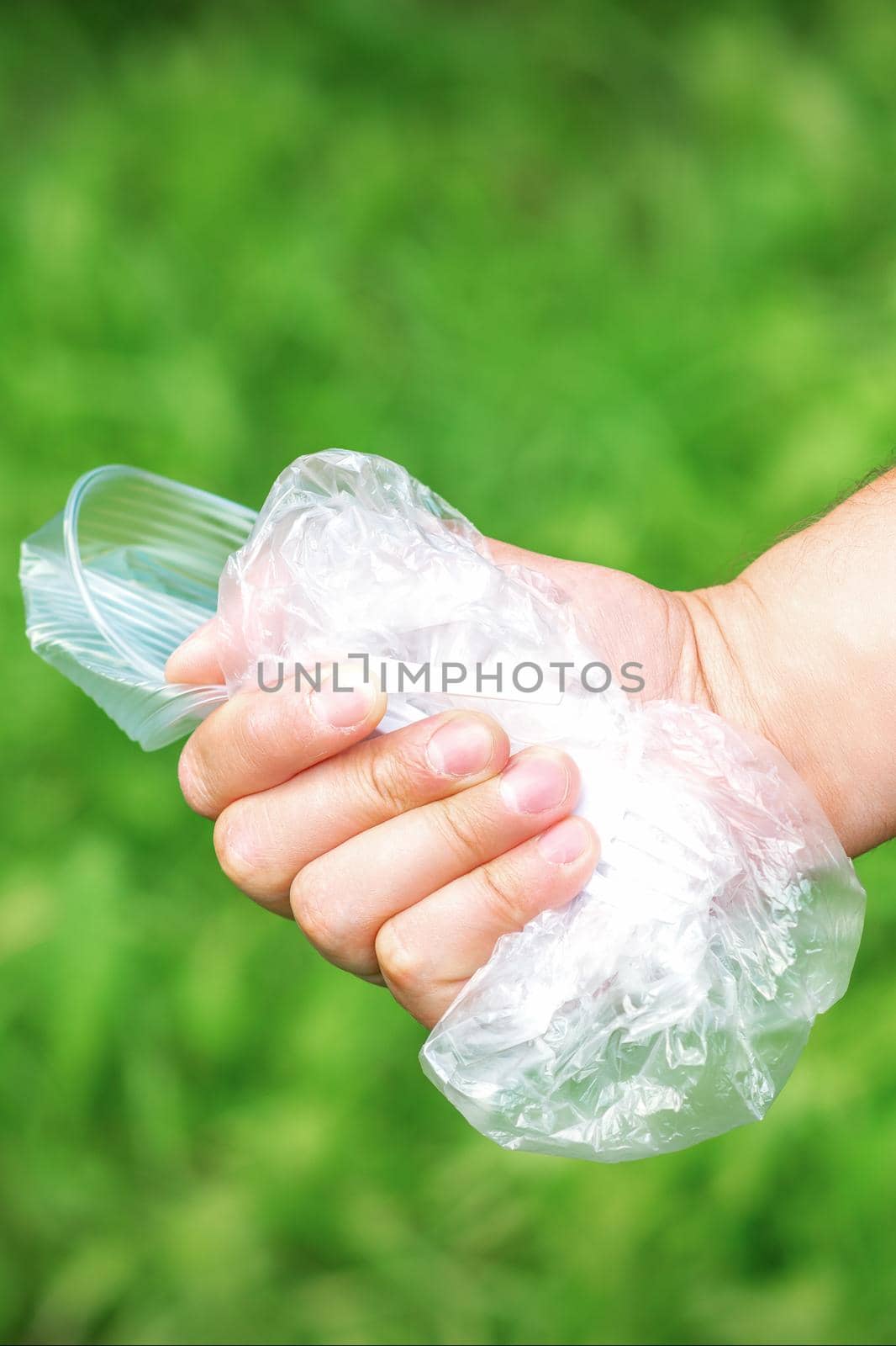 The person holds used crumpled plastic debris in his hand. Environmental problem concept.