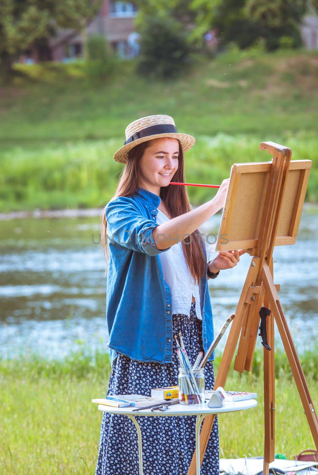 beautiful girl artist outdoor with wooden aesel and watercolor