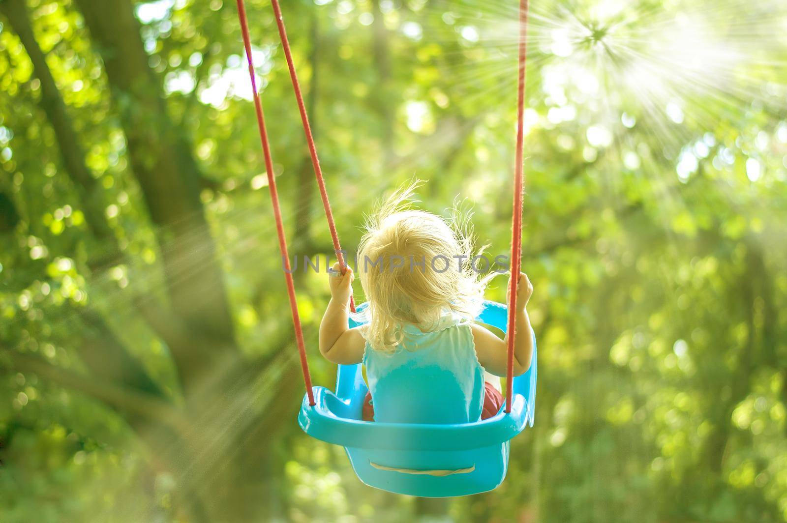 toddler girl on a swing in the park. High quality photo