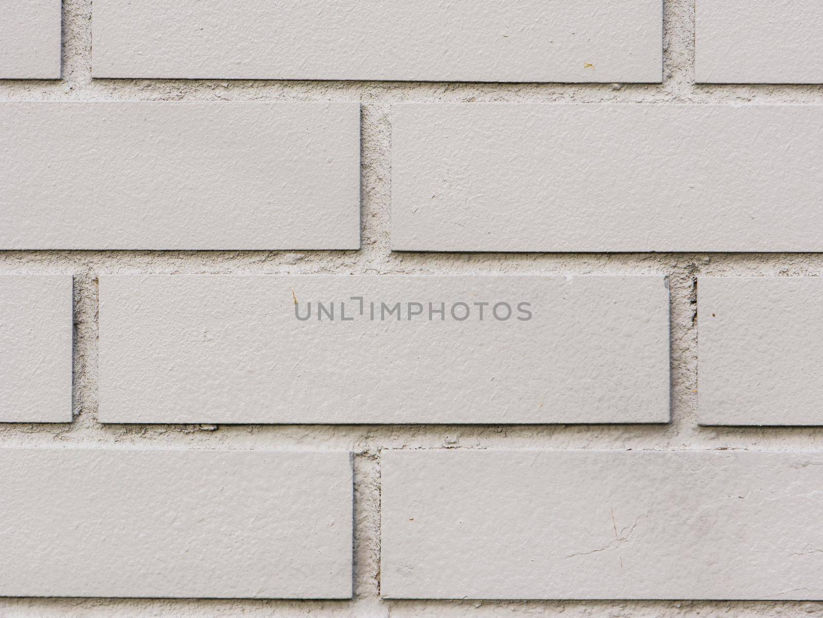 Painted brick wall and weathered sidewalk.