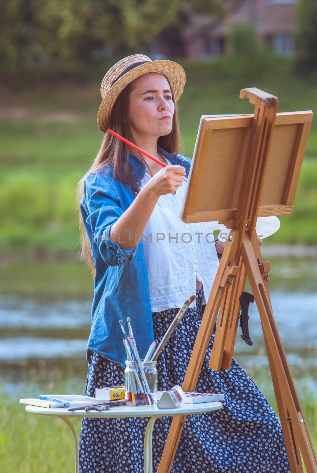 beautiful girl artist outdoor with wooden aesel and watercolor