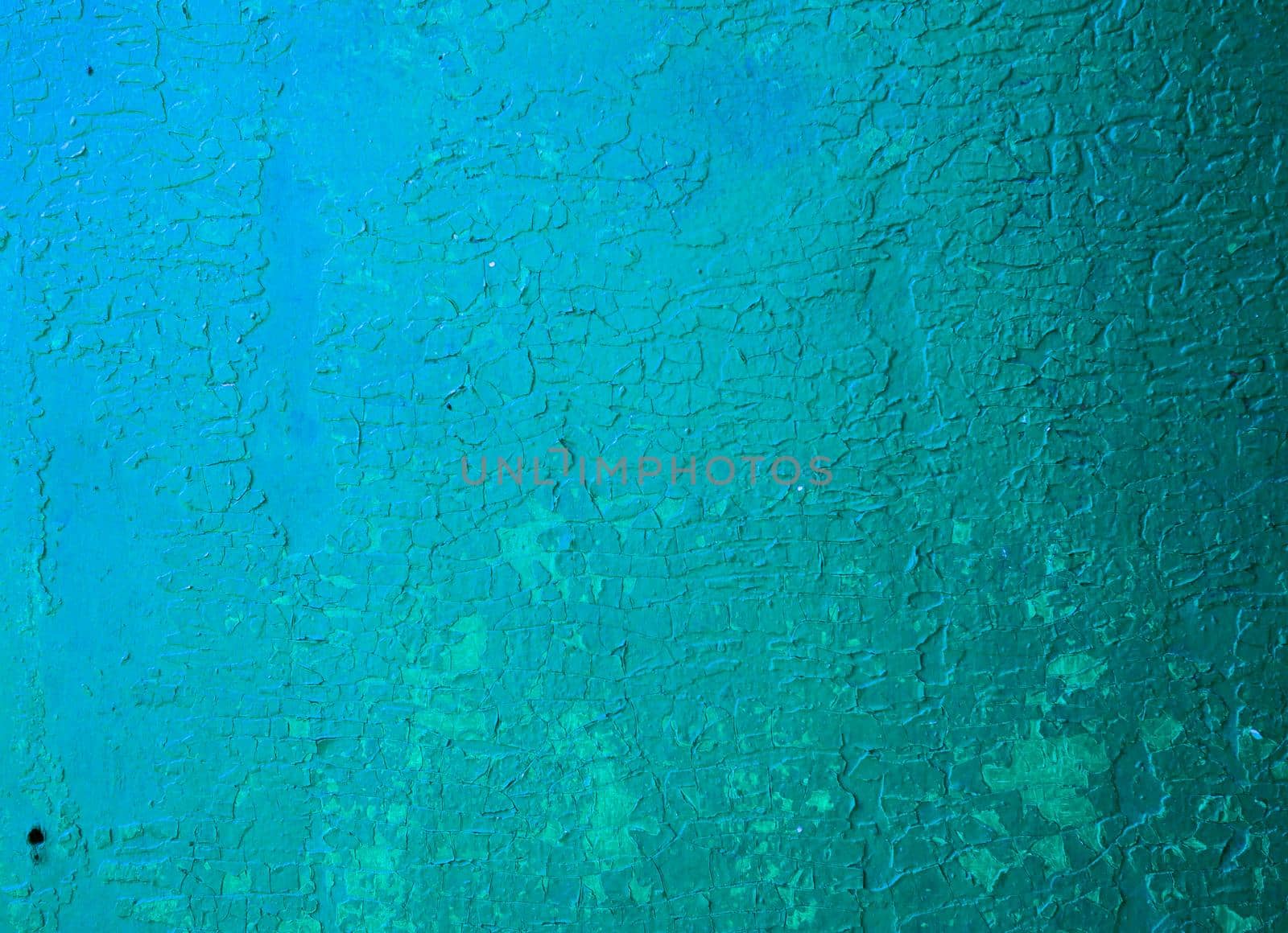 Abstract texture from old cracked paint on a concrete wall. Wall with cracked blue paint.