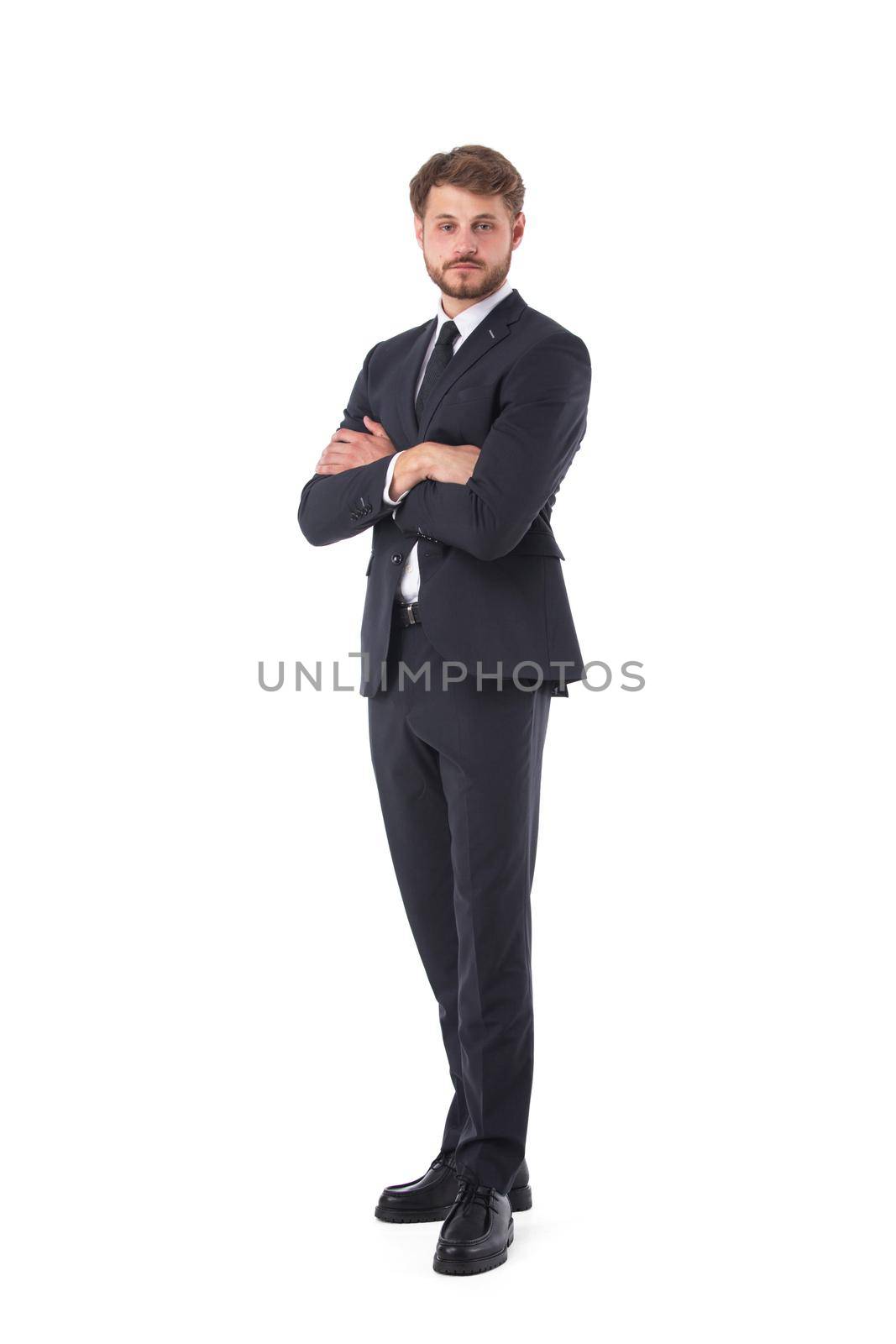 Young businessman wearing black suit standing with arms crossed to chest and posing on white studio background