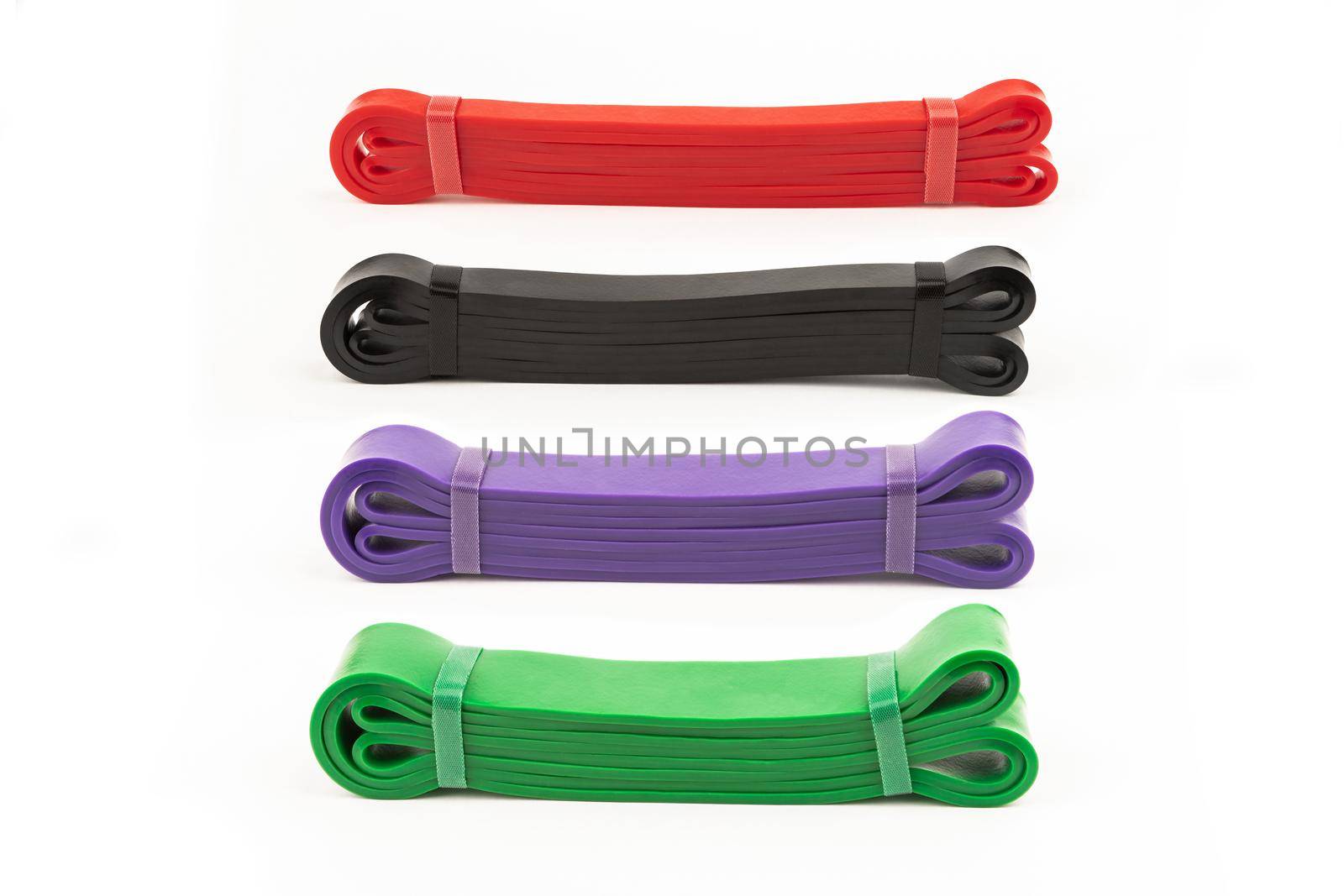 four multi-colored fitness elastic bands of different loads for training on muscle groups by bySergPo