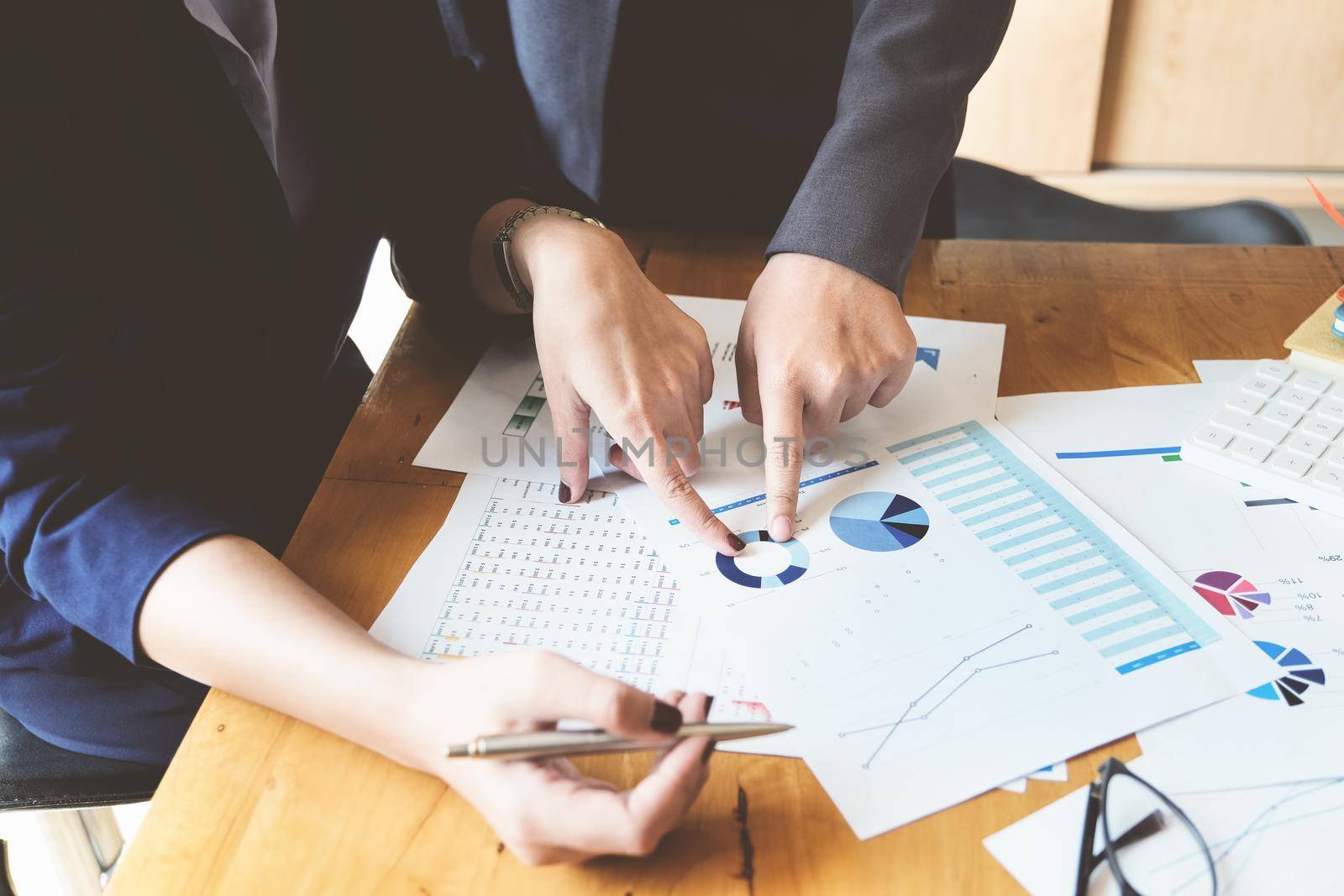 An auditor pointing to documents to examine budgets and financial fraud