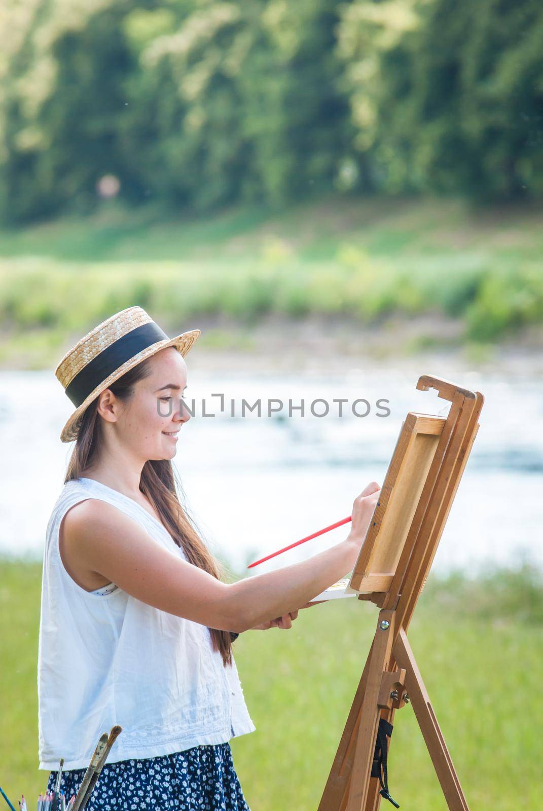 beautiful girl artist outdoor with wooden aesel and watercolor