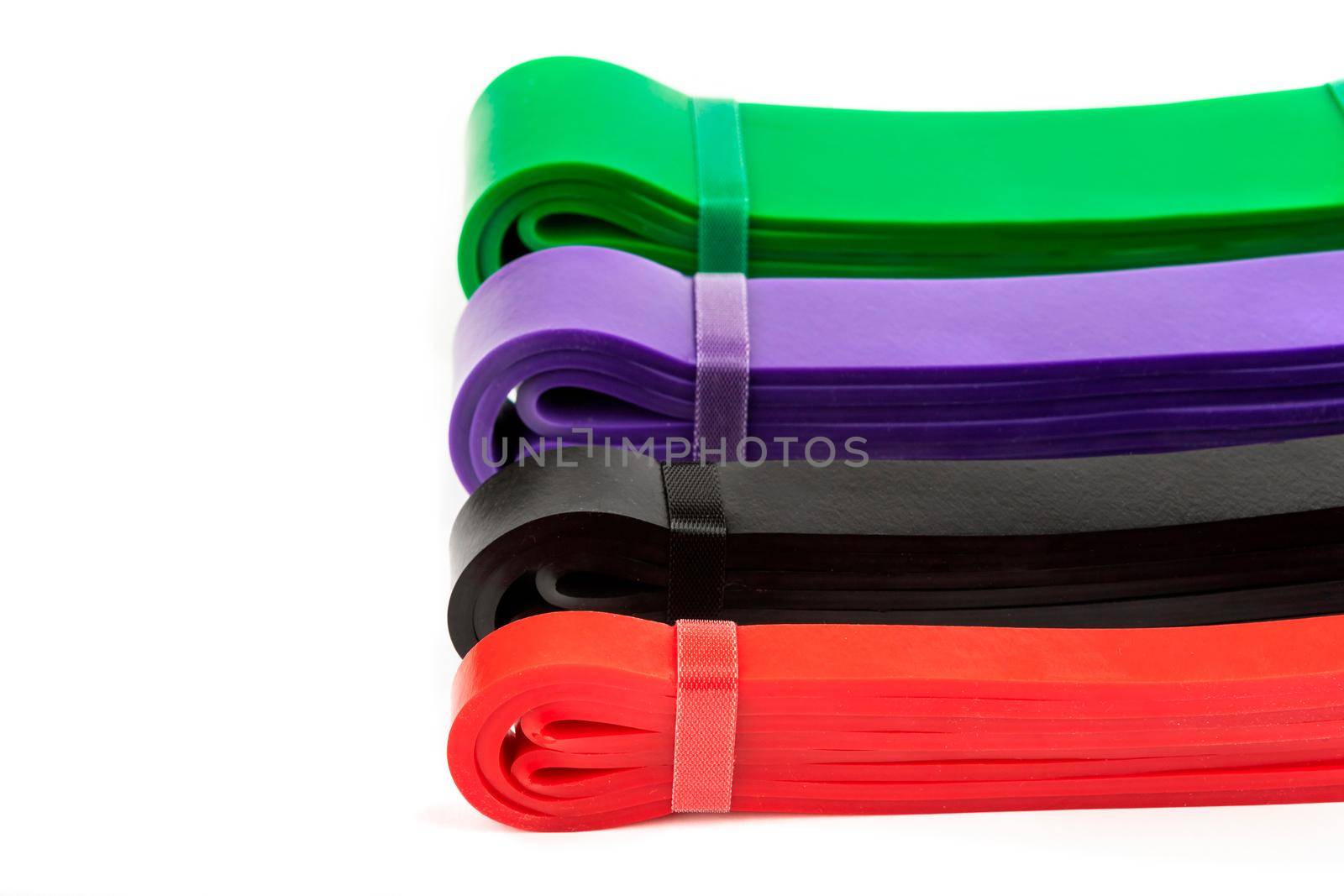 four multi-colored fitness elastic bands of different loads for training on muscle groups by bySergPo