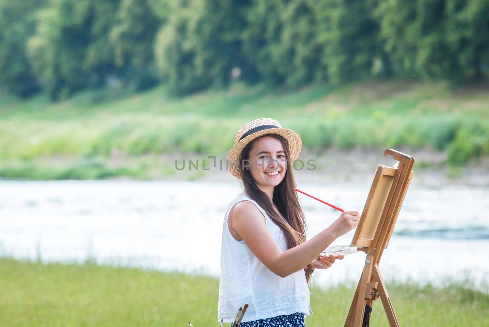 beautiful girl artist outdoor with wooden aesel and watercolor